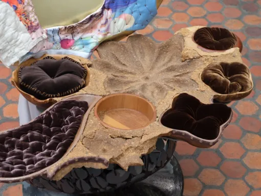 Close-up of a chair with carved wooden bowls as the seat.