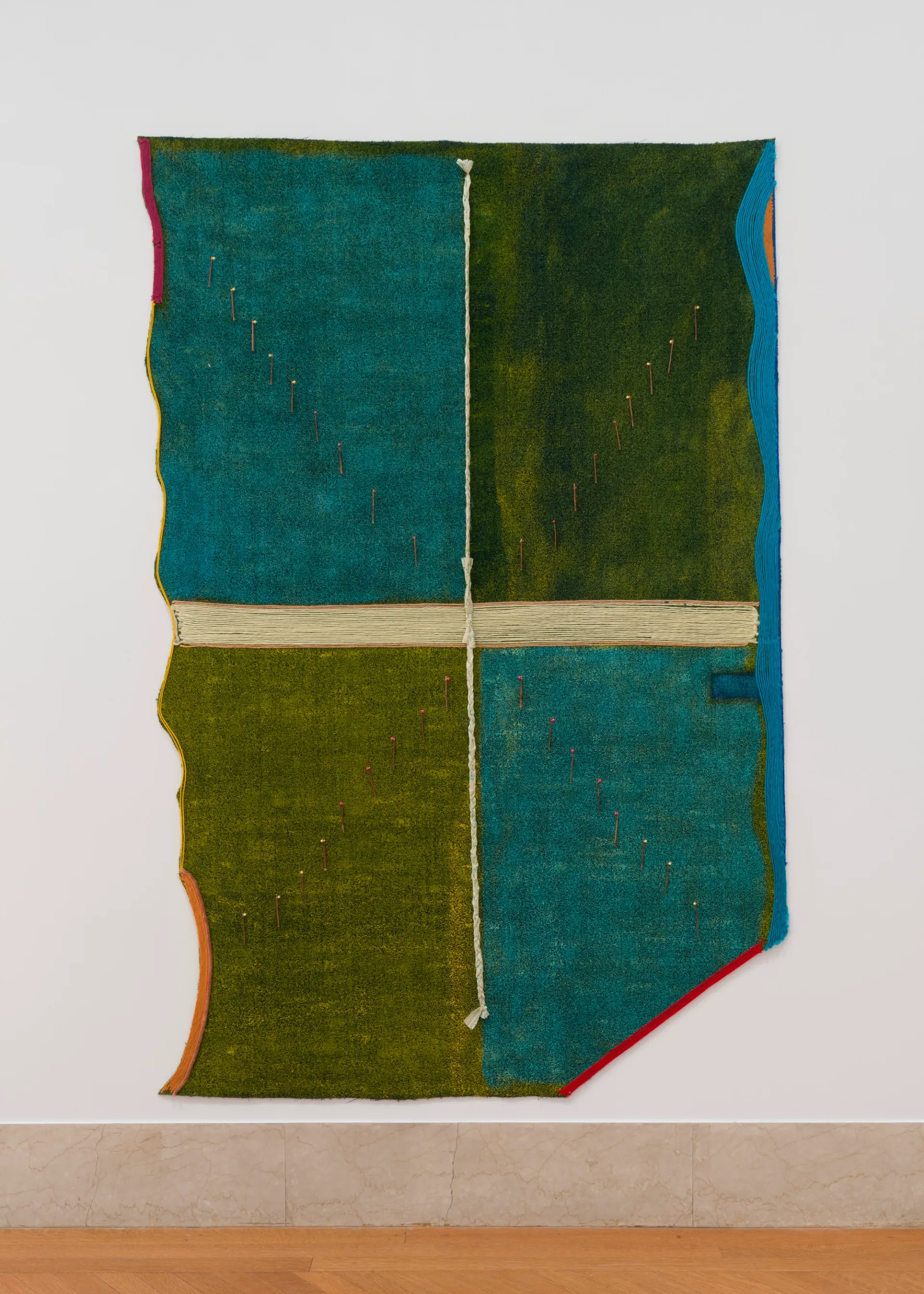 Large painting on the wall in a gallery; irregularly shaped rectangle divided into four painted quandrants by lines of yarn