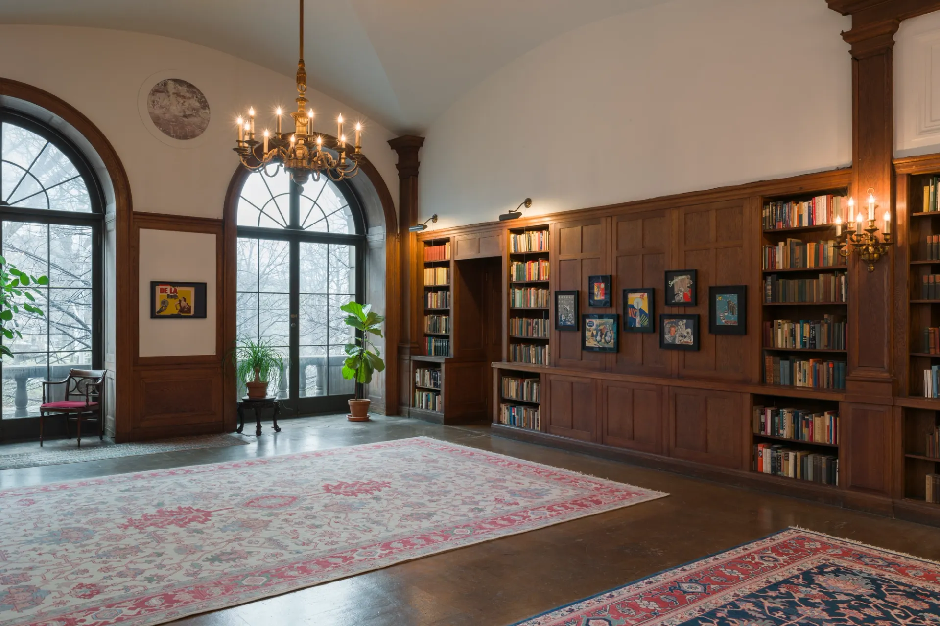 Framed collages in wood-paneled library