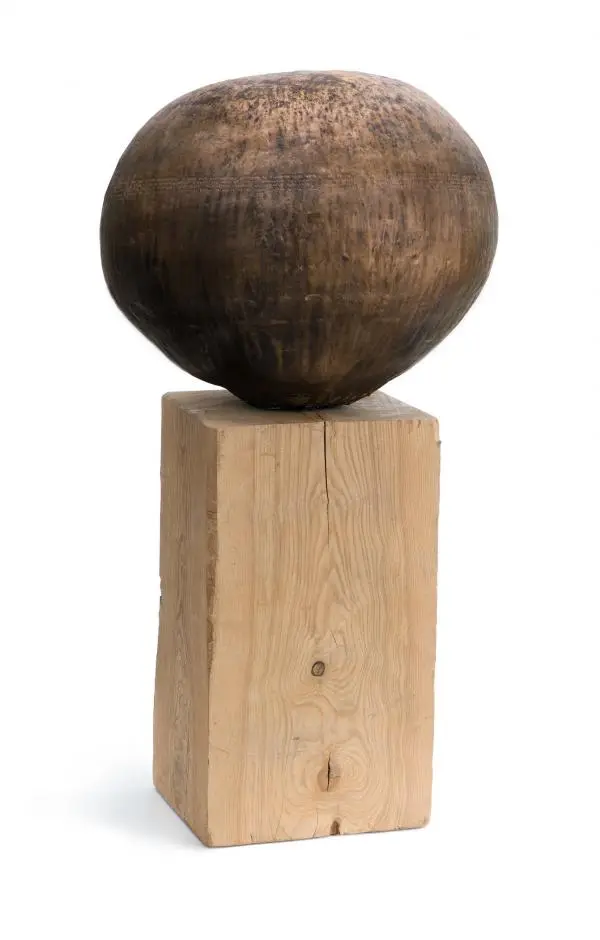 Sculpture composed of wooden orb on vertical wooden base