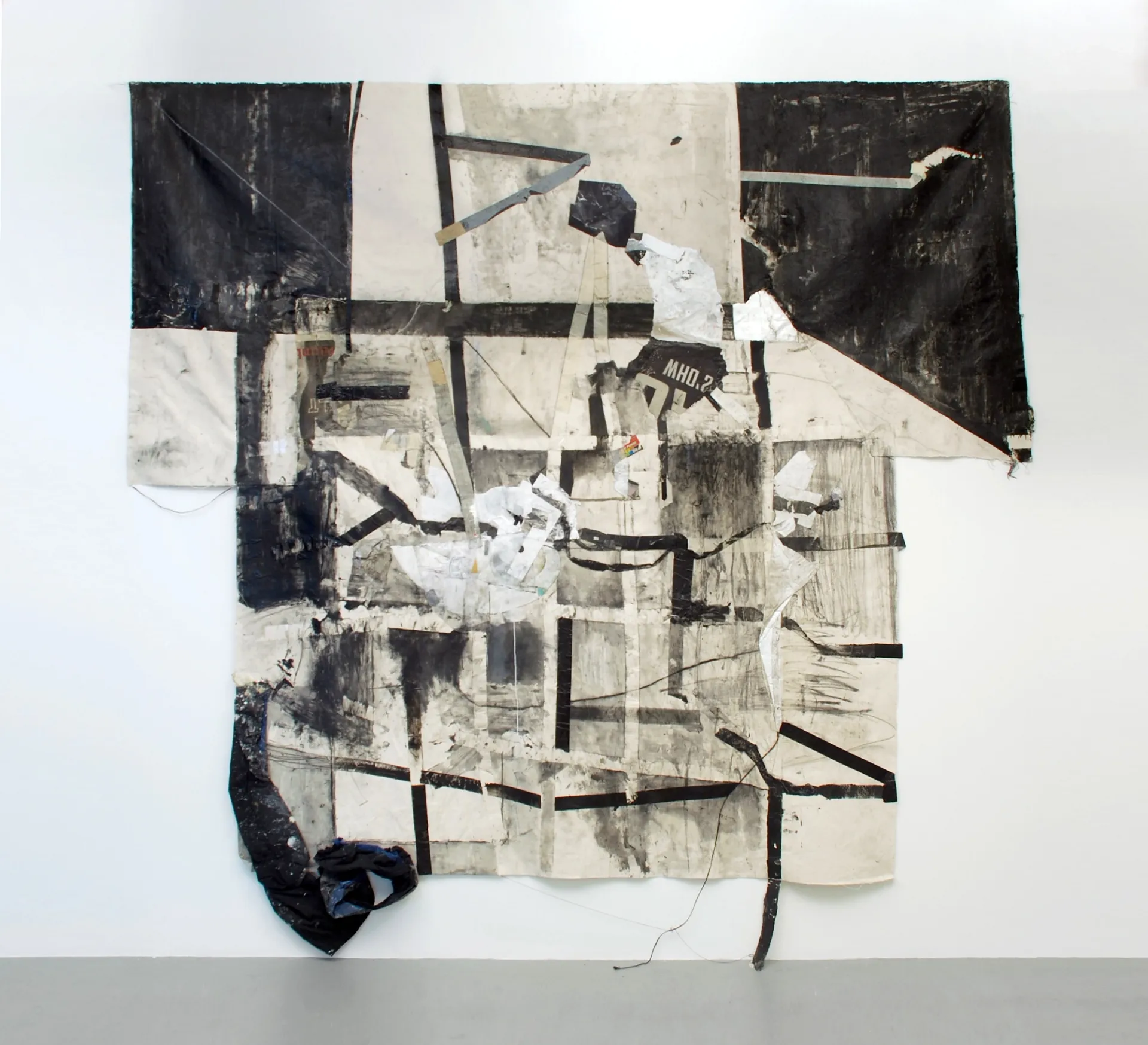 A large, irregularly shaped black and white abstract painting.