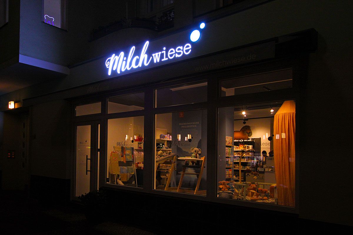 Laden mit Leuchtschrift über dem Schaufenster am Abend
