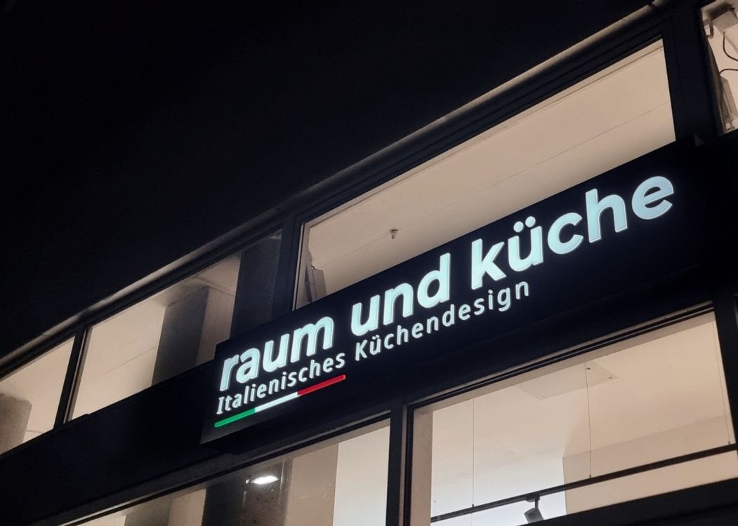 Leuchtkasten mit leuchtender Schrift und Streifen in Grün, Weiß und Rot