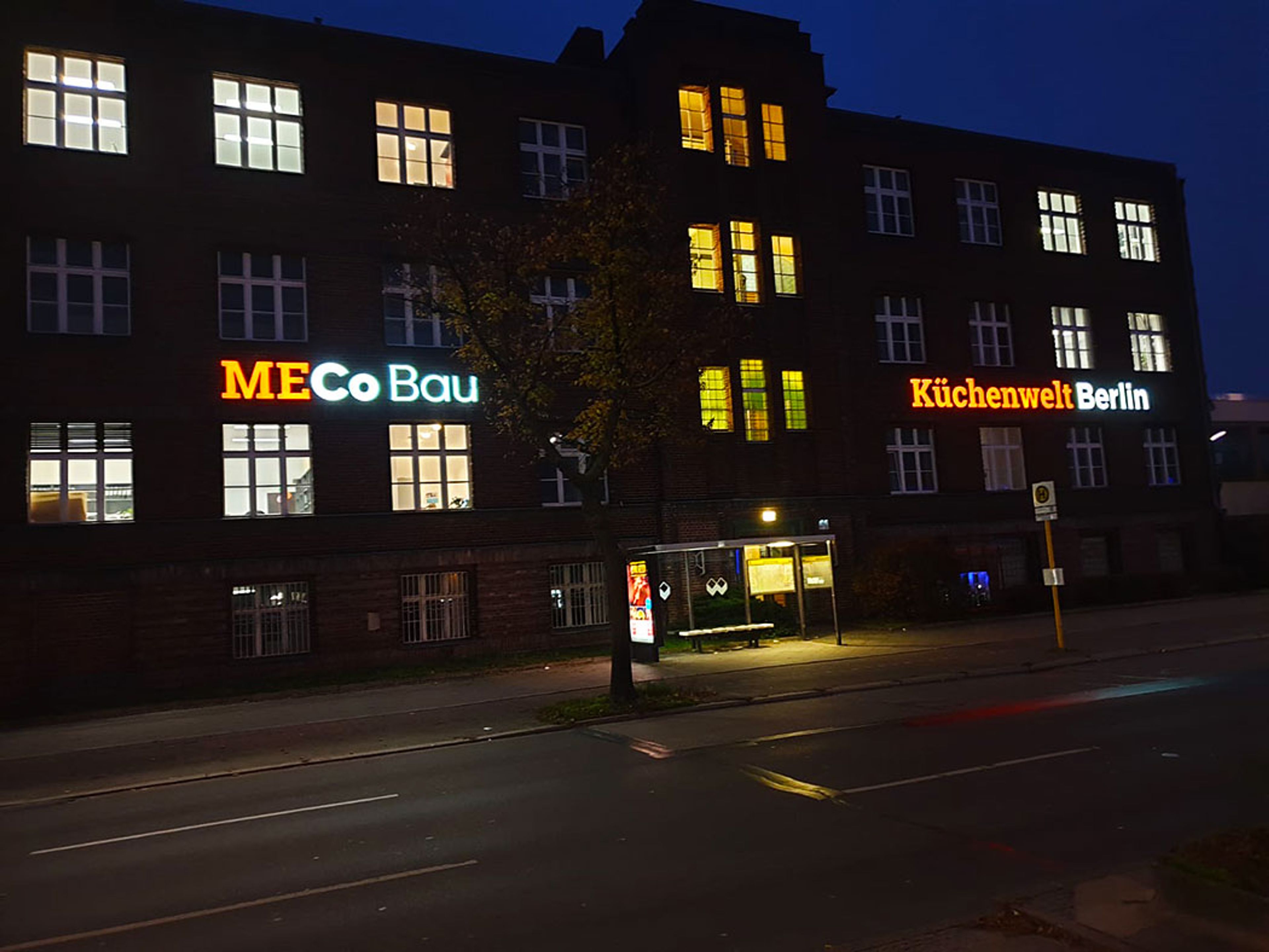 Leuchtbuchstaben an der Fassade eines mehrstöckigen Gebäudes am Abend