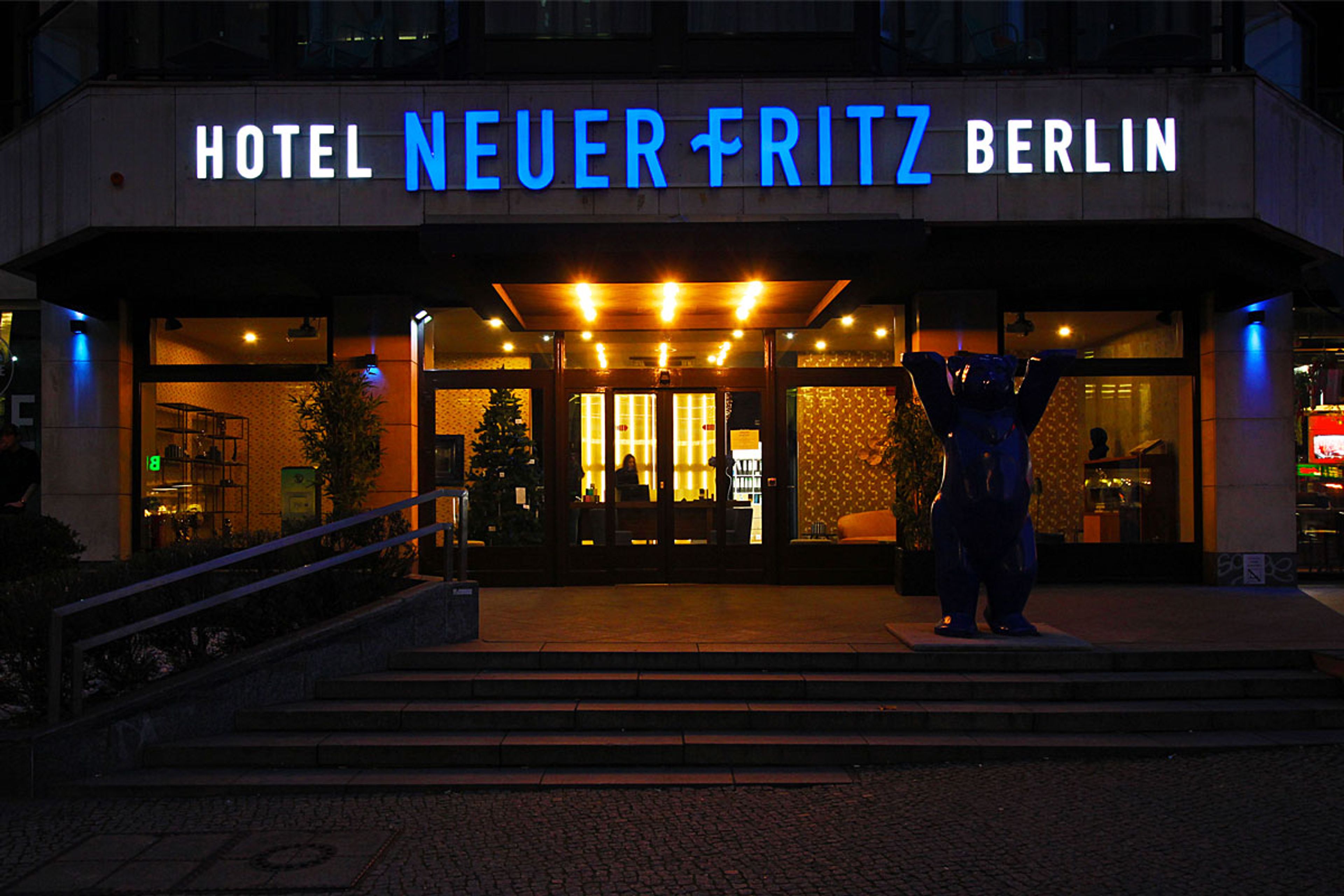 Leuchtbuchstaben über dem Eingang eines Hotels am Abend