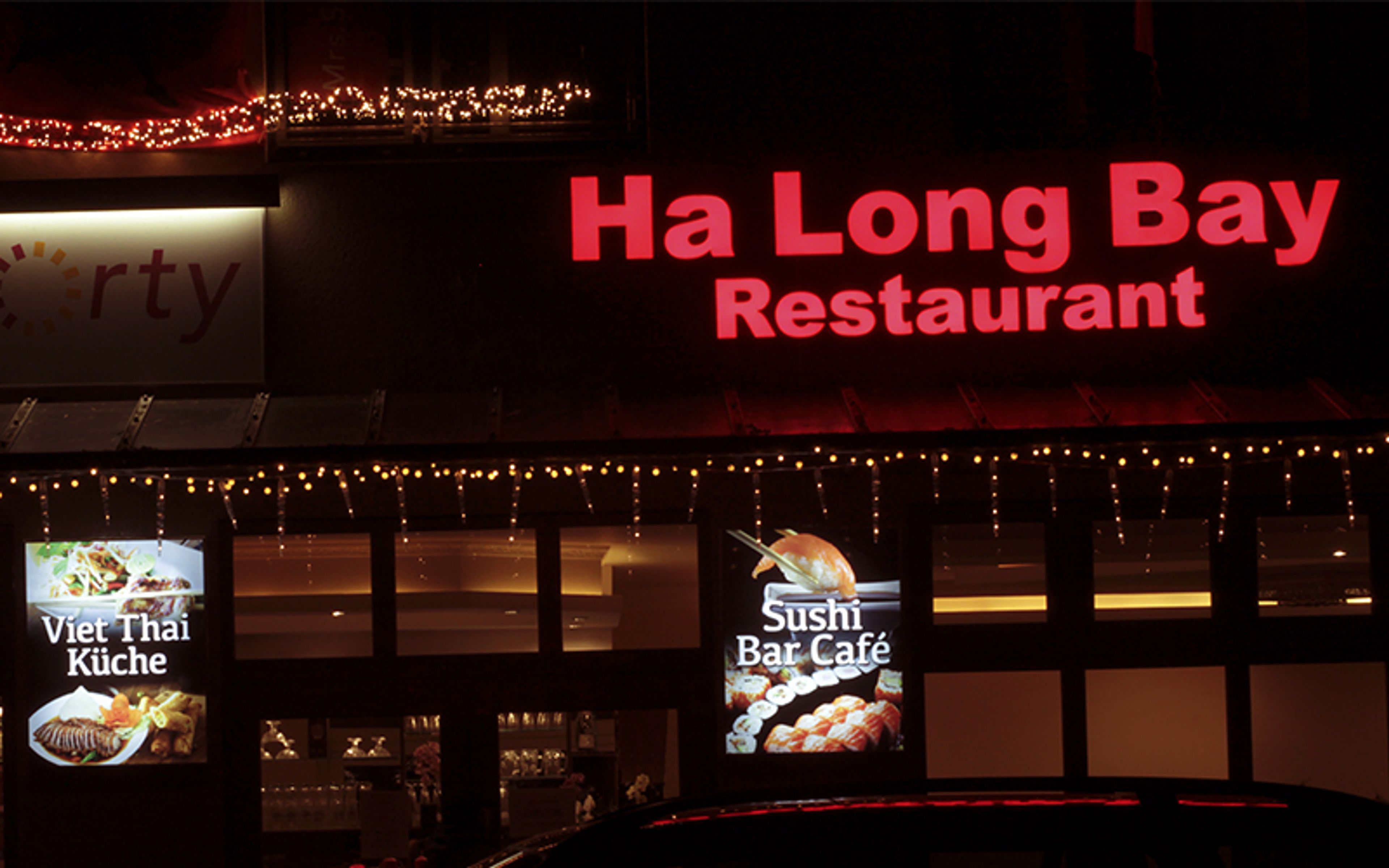 Rote Leuchtbuchstaben über einem Restaurant am Abend