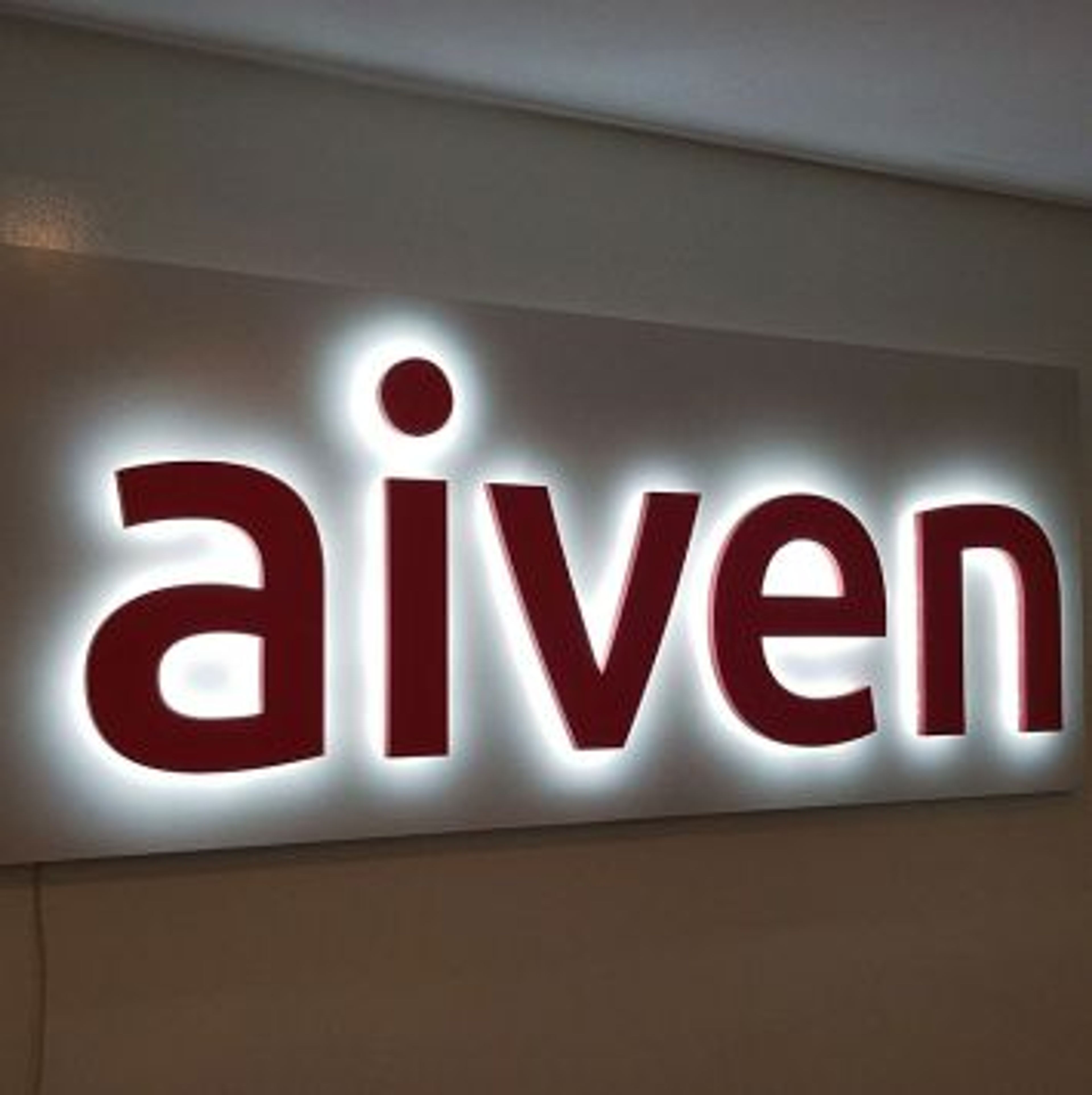 Leuchtbuchstaben mit hellem Lichtschein an einer hellen Wand