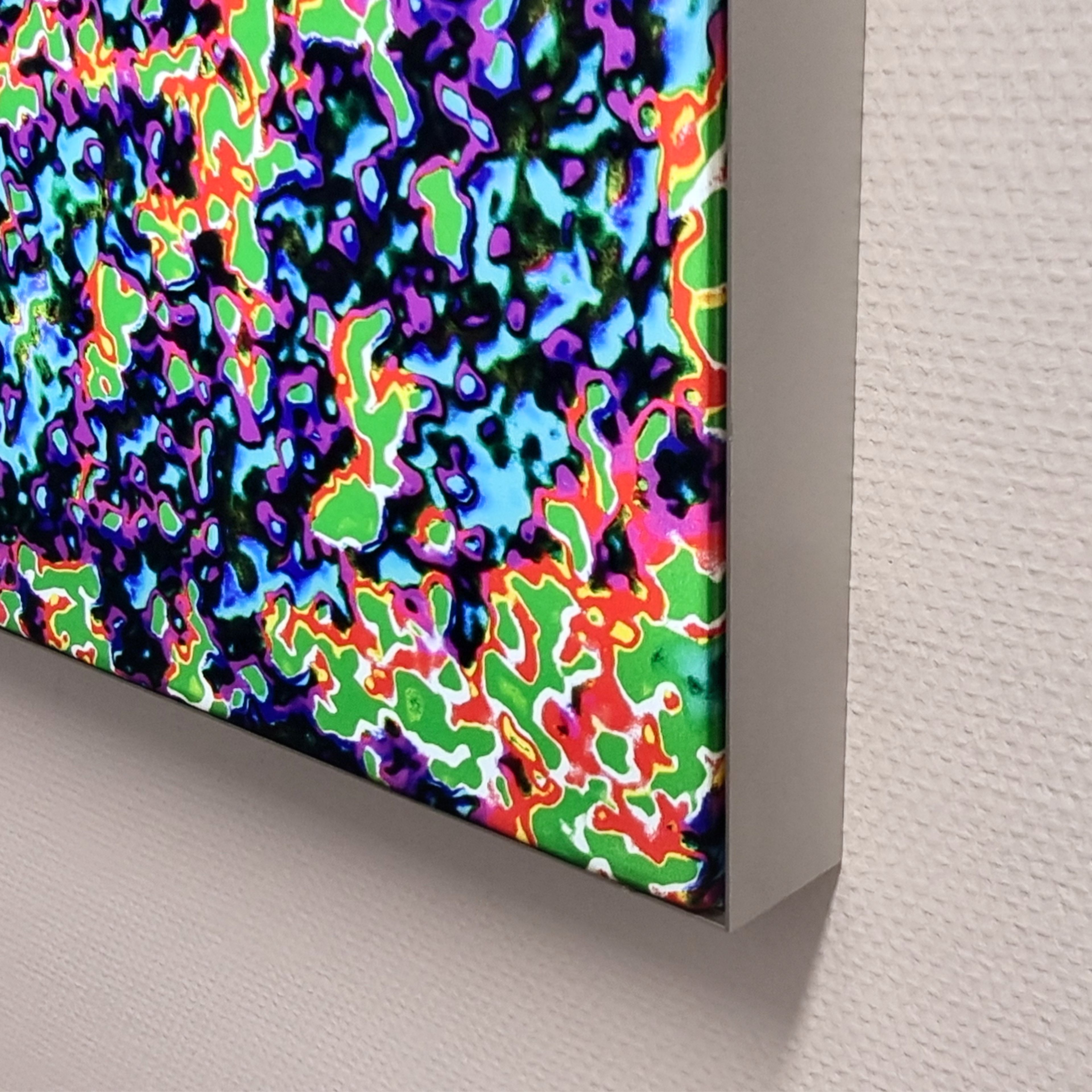 Beleuchteter Stoffrahmen mit buntem Motiv an einer Wand