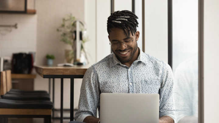 Man smiling while using laptop