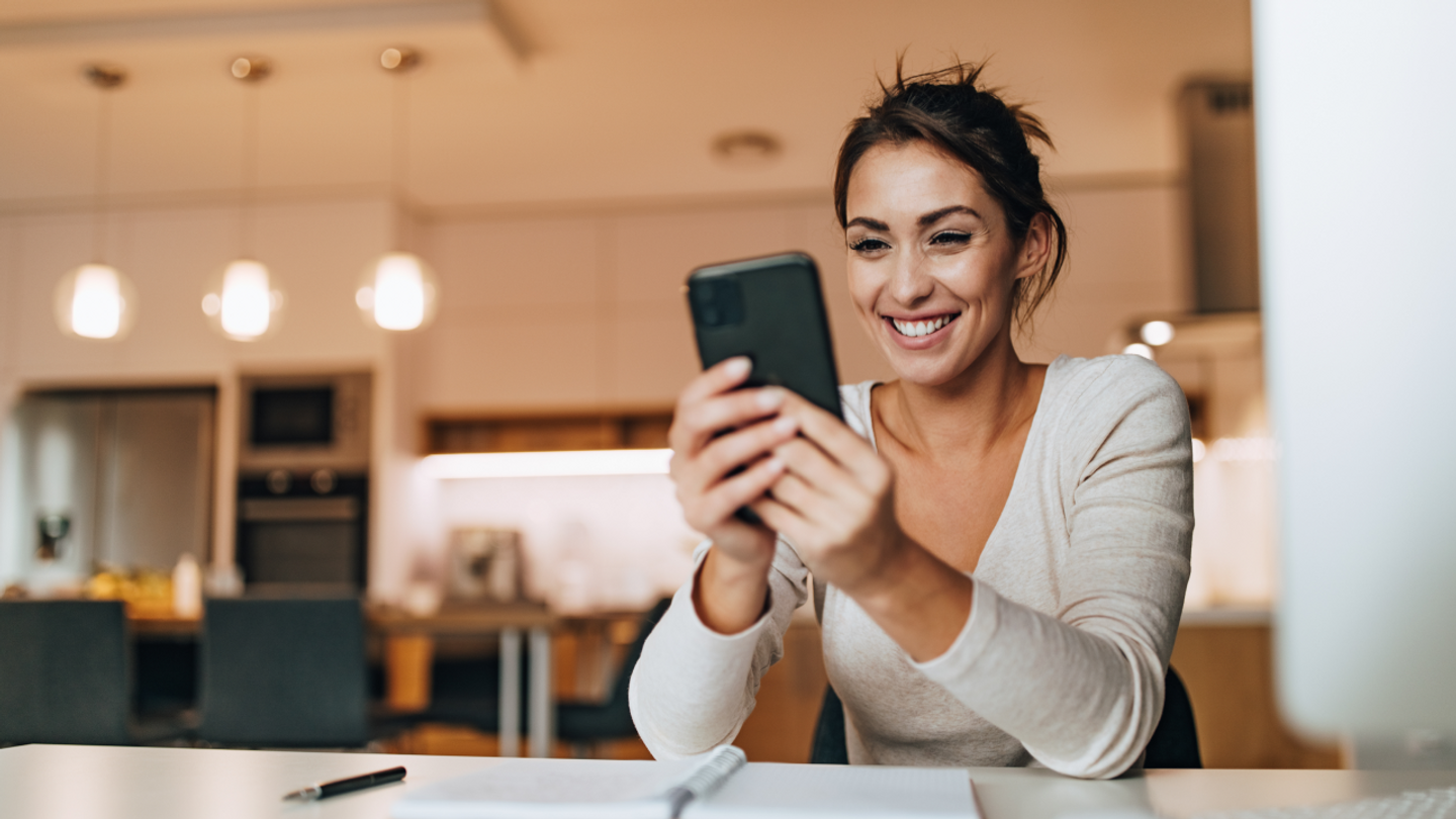 Woman smiling using smartphone