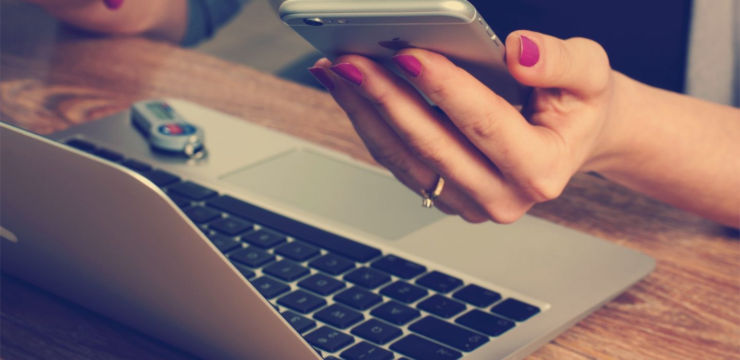 Hands using laptop and mobile device