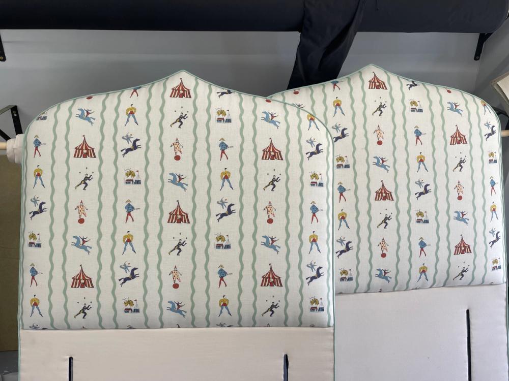 A pair of matching headboards upholstered in circus themed pattern