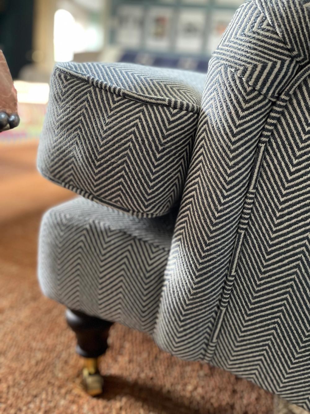 Close up detail of piping on three seater sofa in light grey pinstripe fabrics
