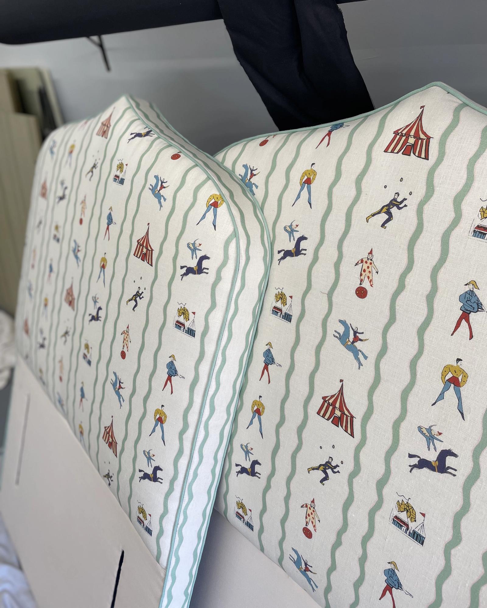 Two matching headboards with circus-style pattern and light green piping