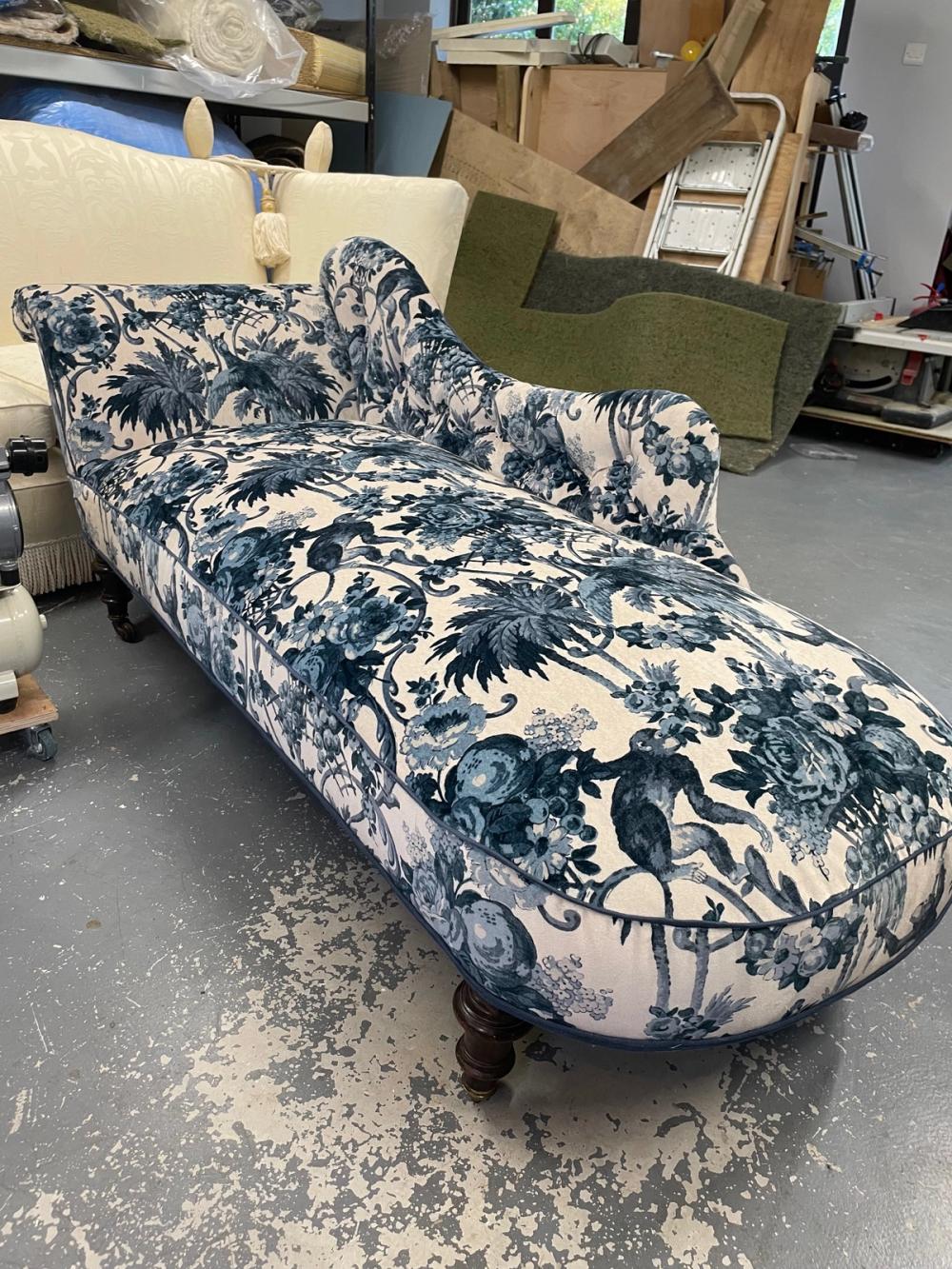 Chaise longue in blue floral velvet fabric on white background