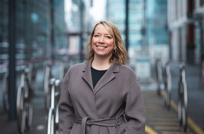 Maren Bjerkeng står ute i bybildet og smiler til kamera.