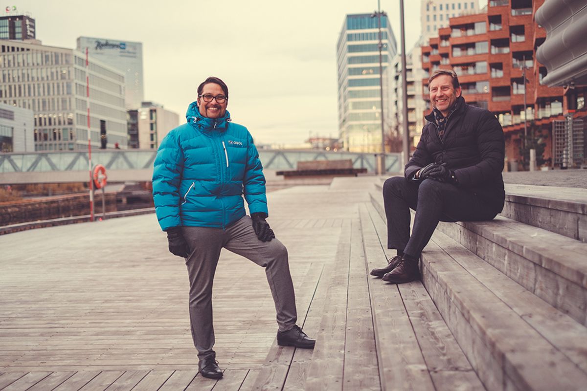 OBOS-sjef, Daniel K. Siraj og styreleder i OMA, Mathis Grimstad smiler på Munch Brygge i Bjørvika