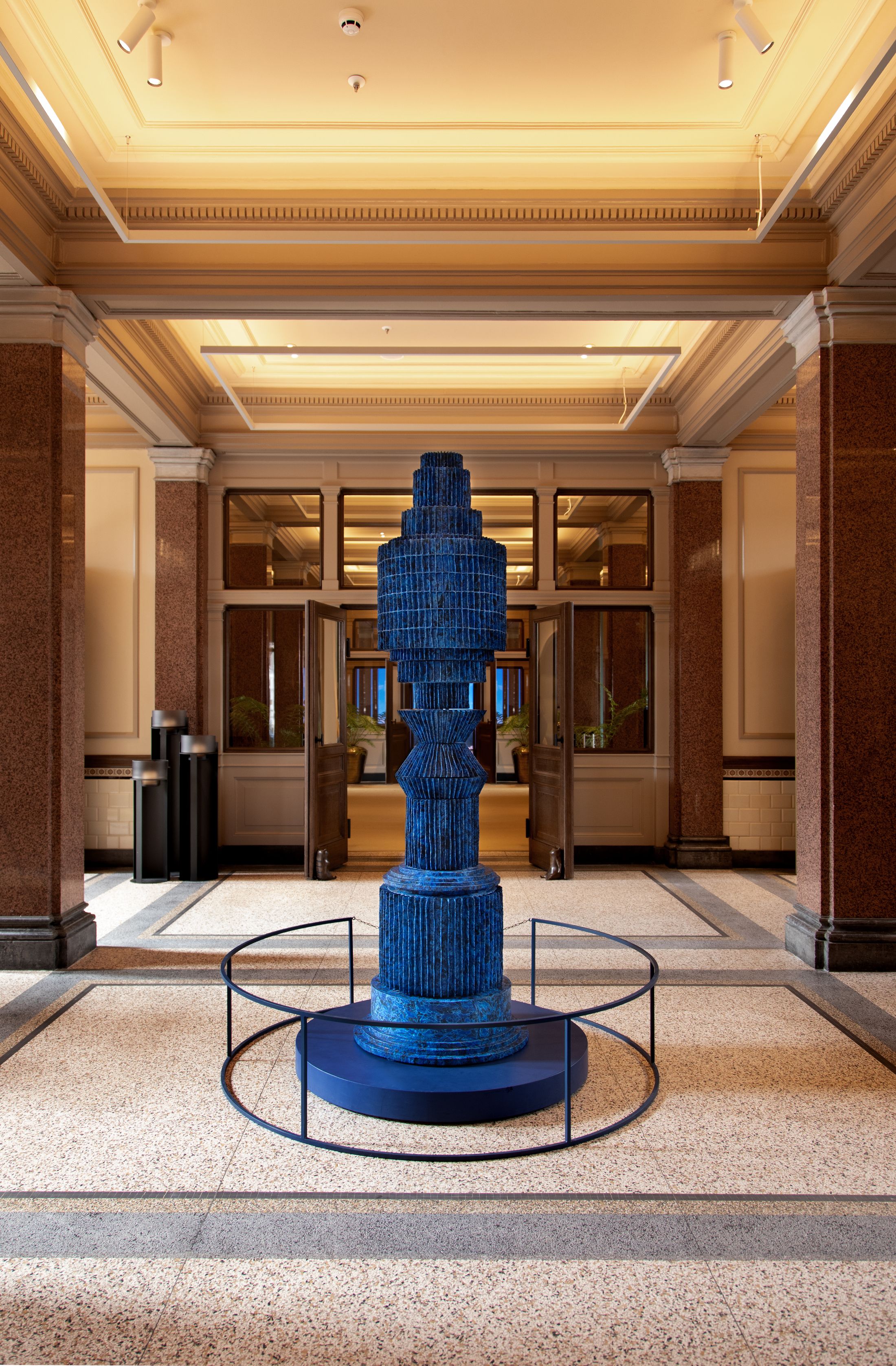 A blue sculpture in the centre of a hallway