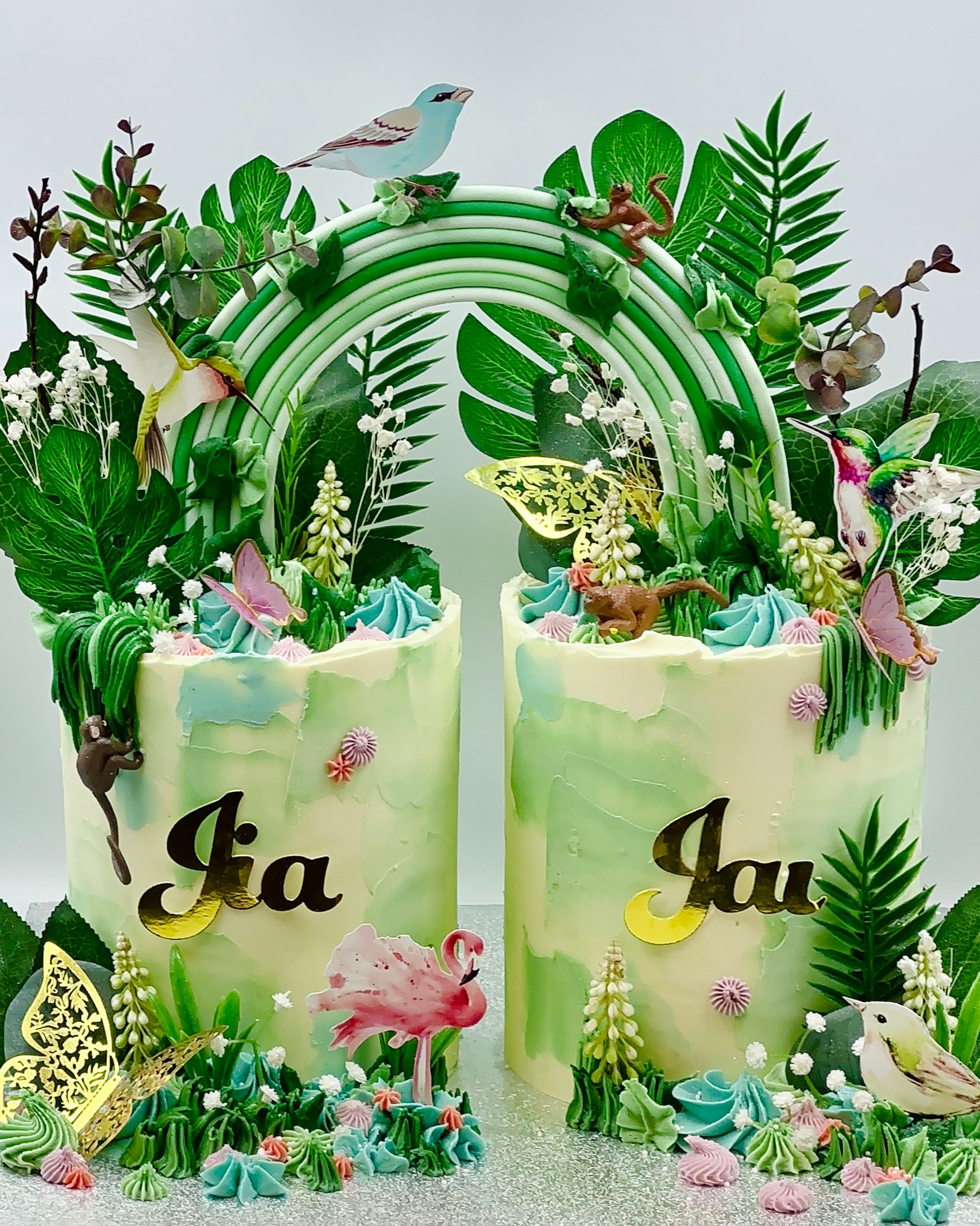 Green cakes connected by a green rainbow with leaves, birds and flowers around it