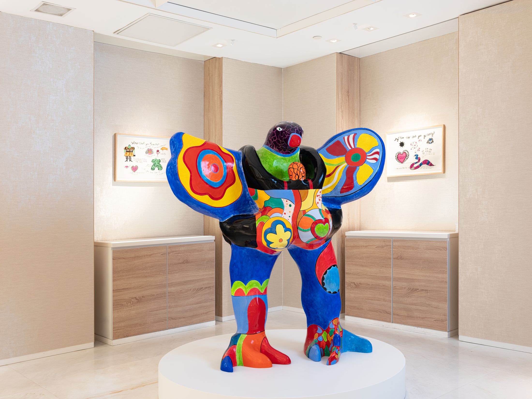 A sculpture of an animal with wings in blue, red and yellow