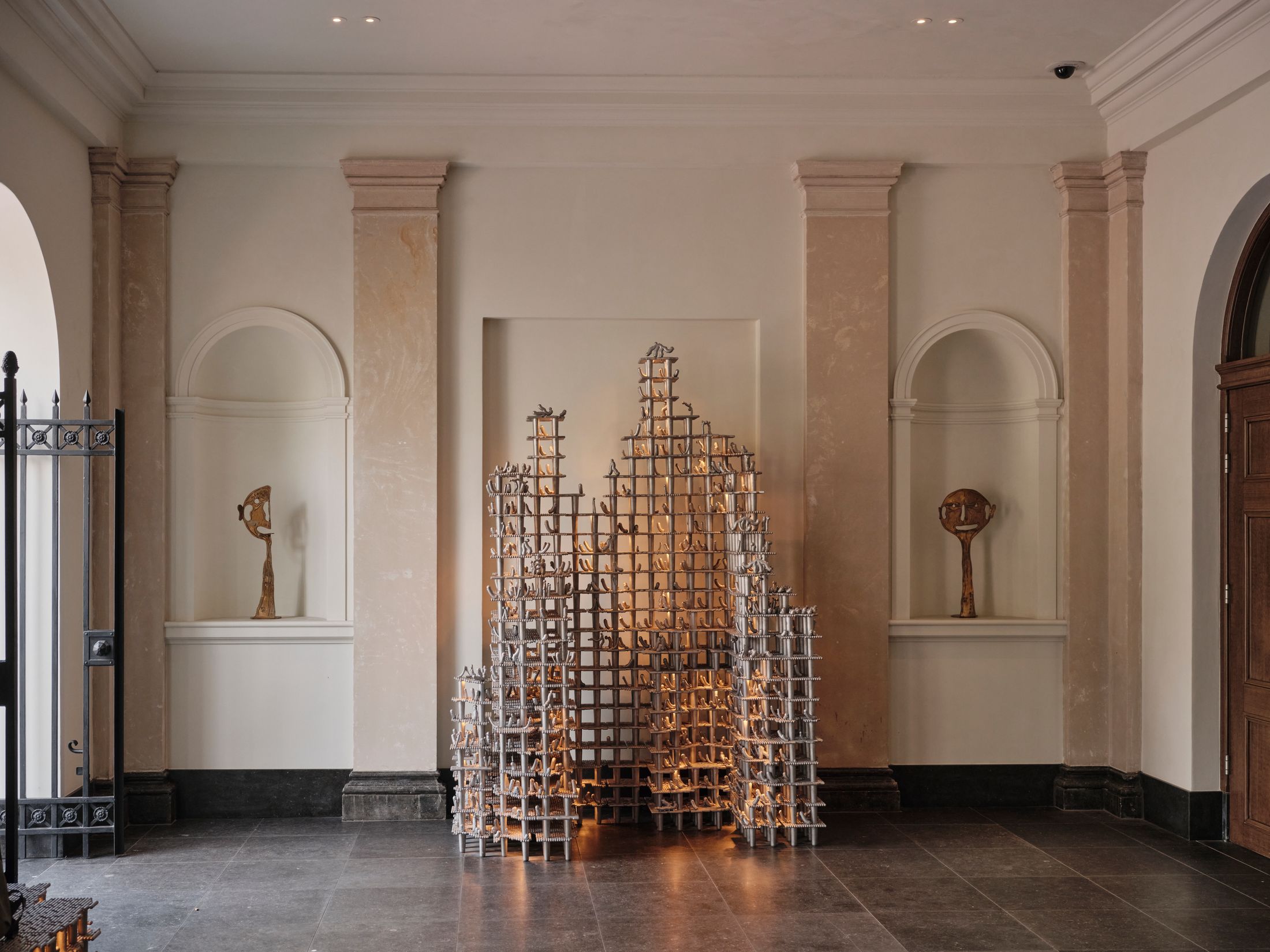 A metal sculpture lit up from behind in a corridor