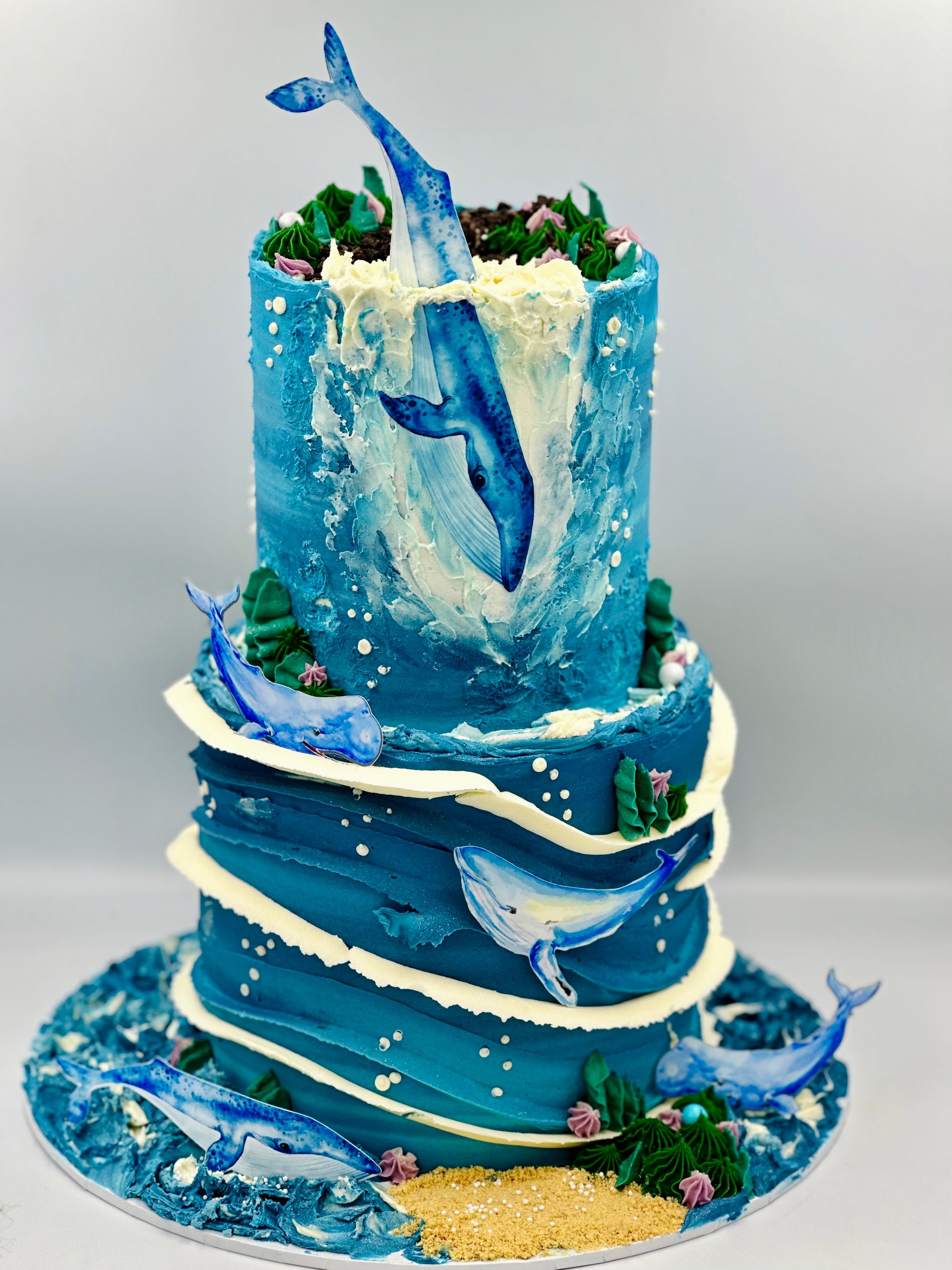 A blue cake with whales around it