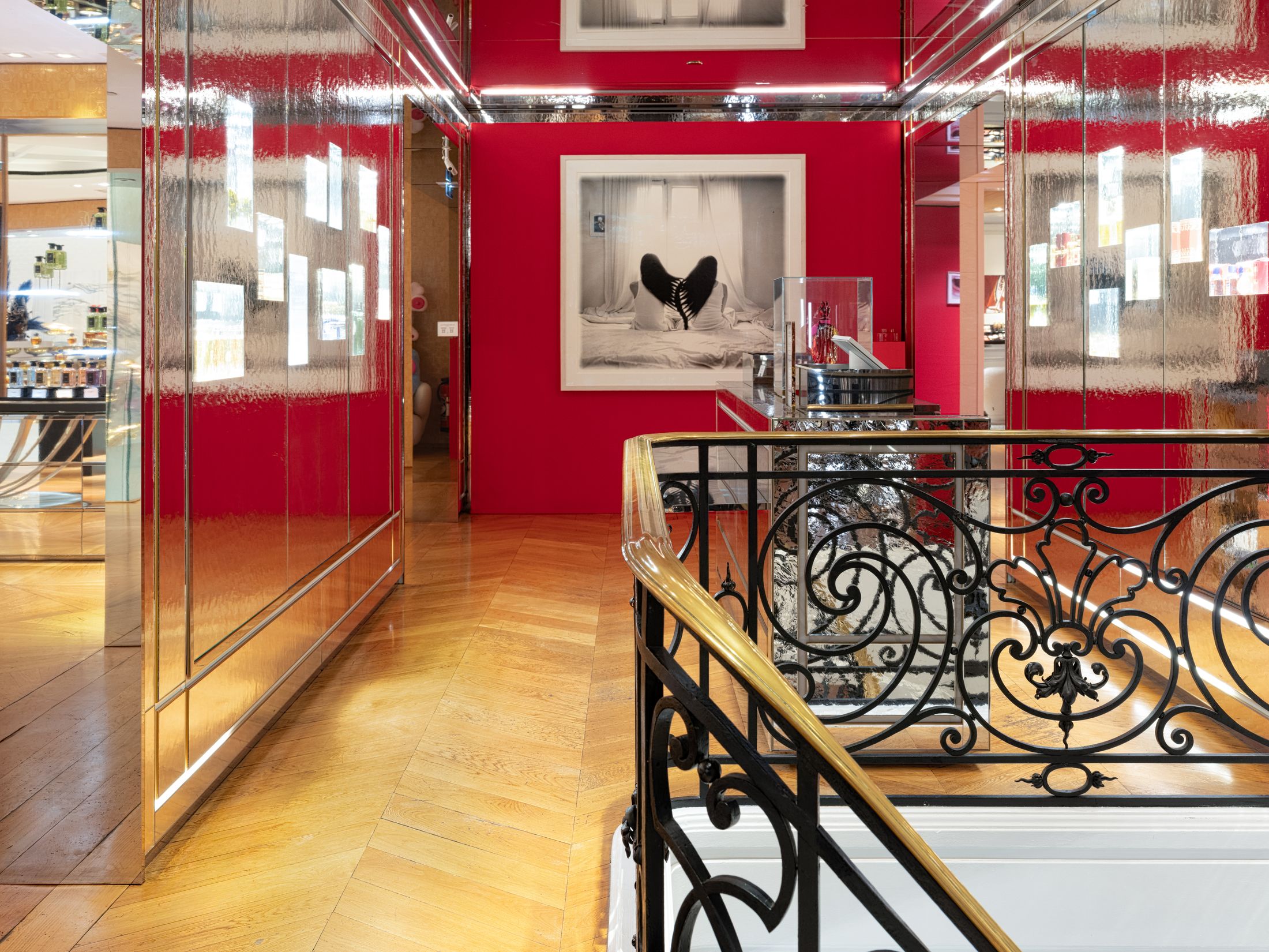 A gold and black staircase with mirror walls and a red back wall