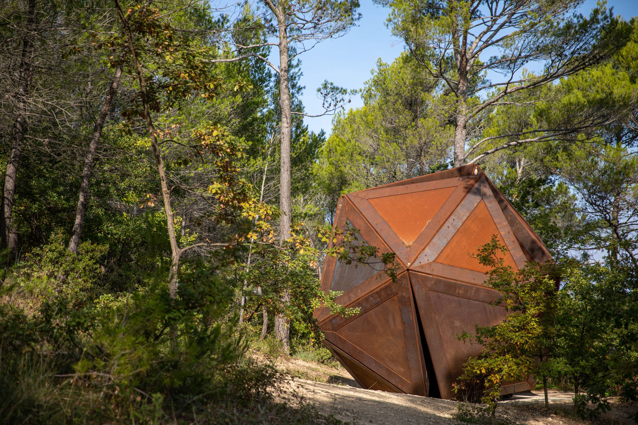 A rusty large 3d pentagon in a forest