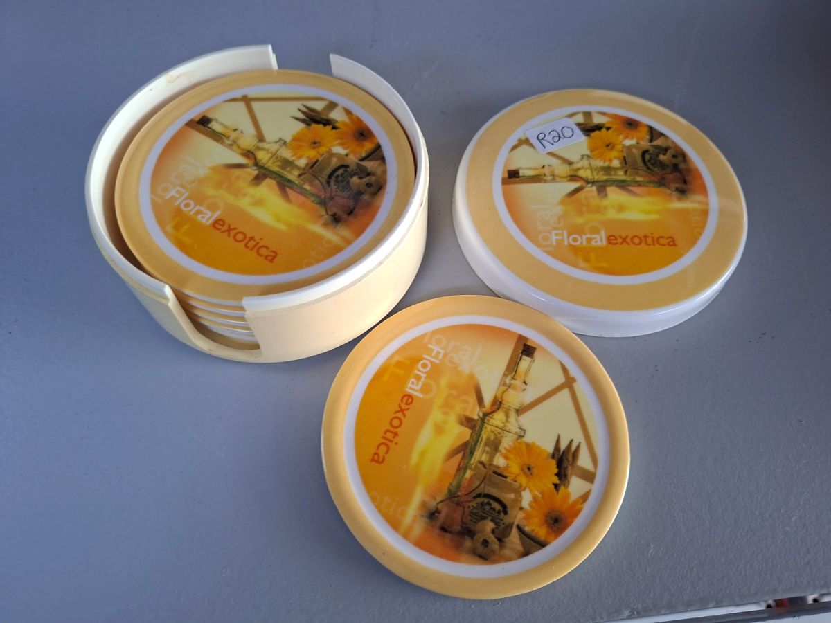 Round floral-themed coaster set with matching storage holder and lid. 4