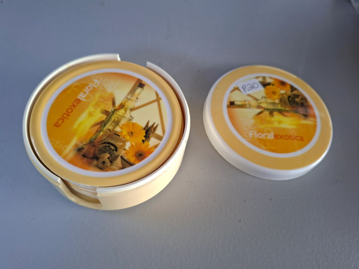 Round floral-themed coaster set with matching storage holder and lid. 3