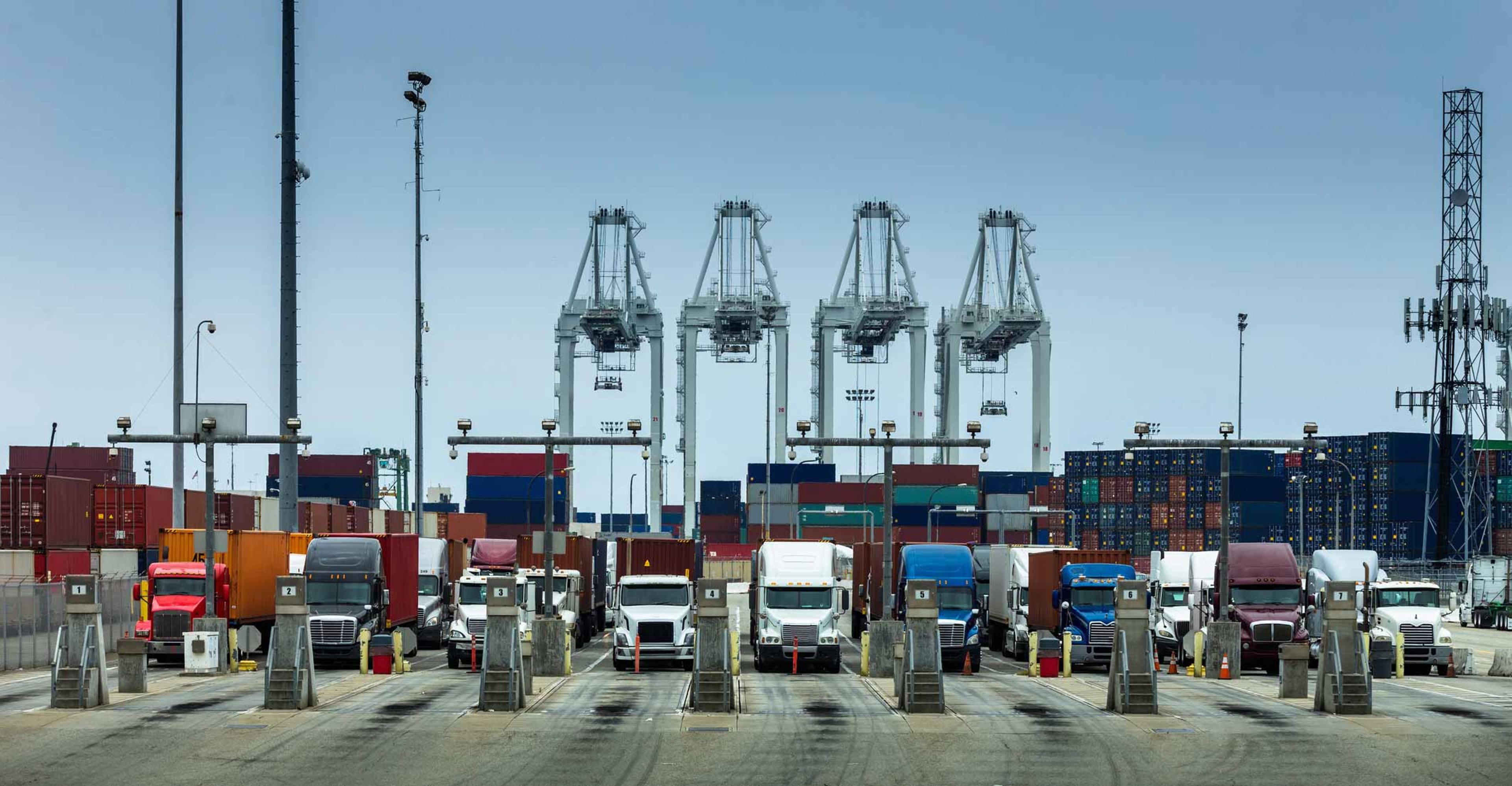 Containers being loaded on trucks at a port.