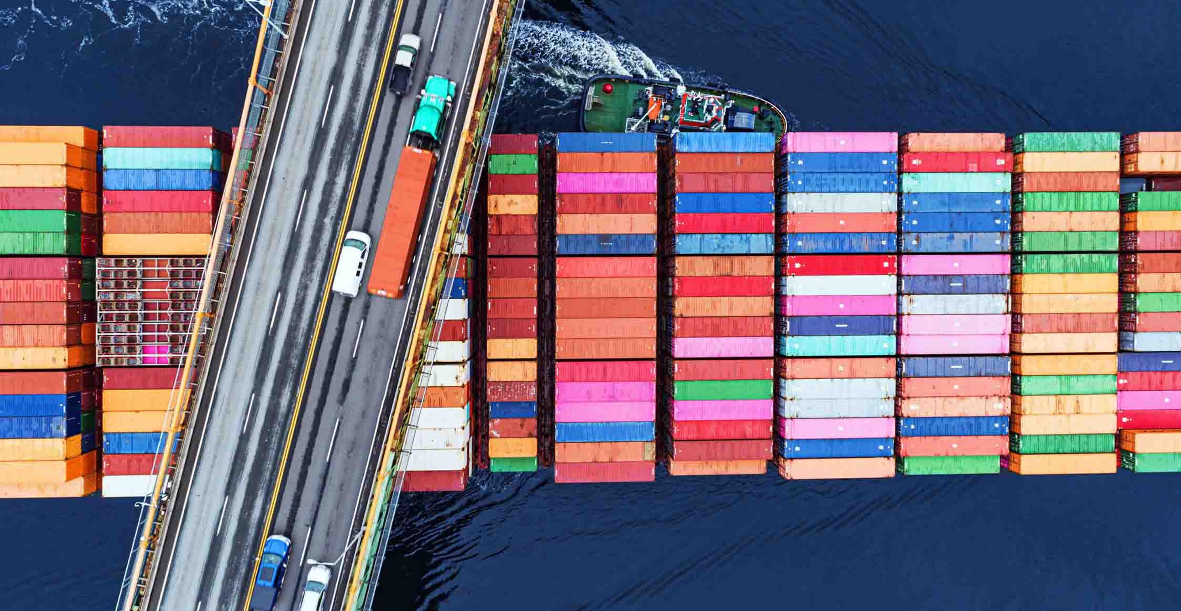 An SSL loaded with freight passing beneath a bridge