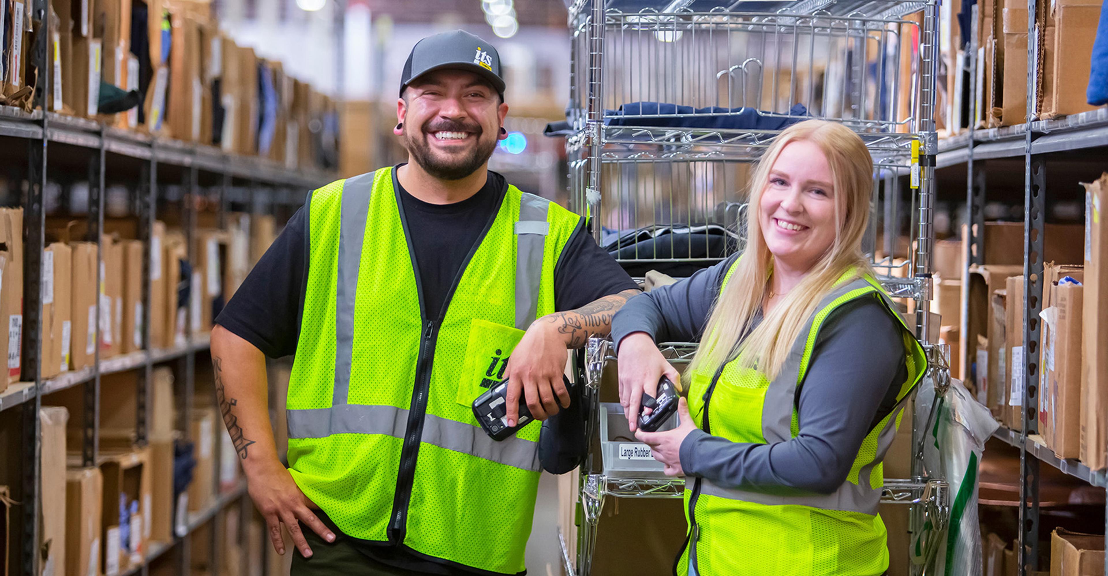 Two ITS team members working in a warehouse aisle