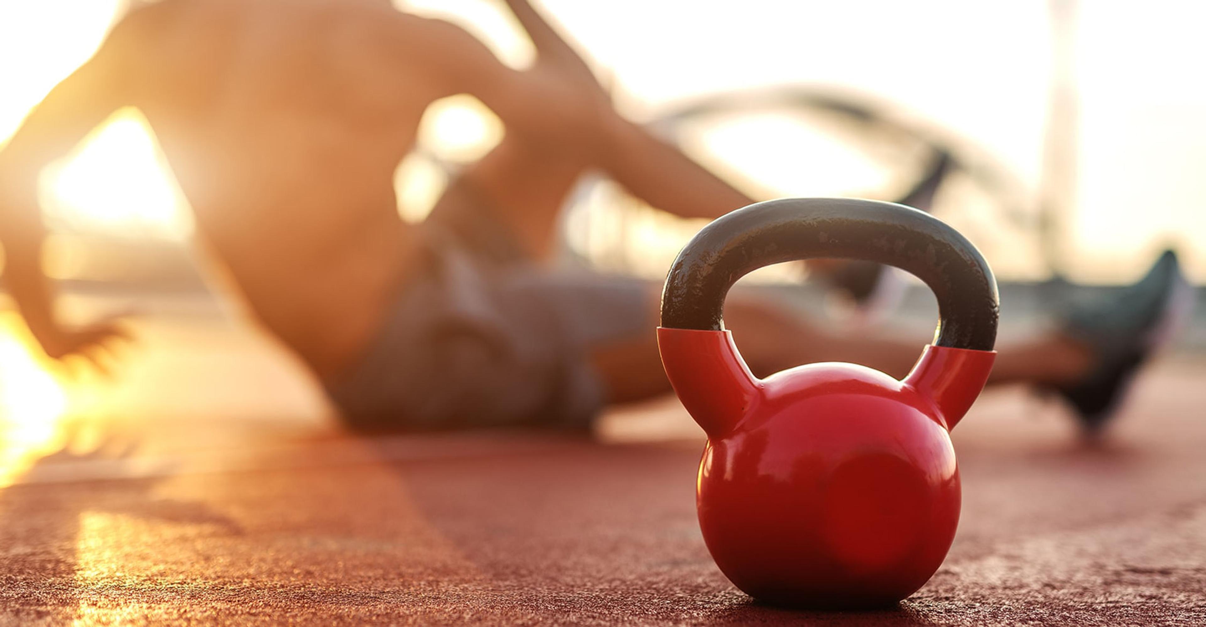A kettlebell with someone working out in the background
