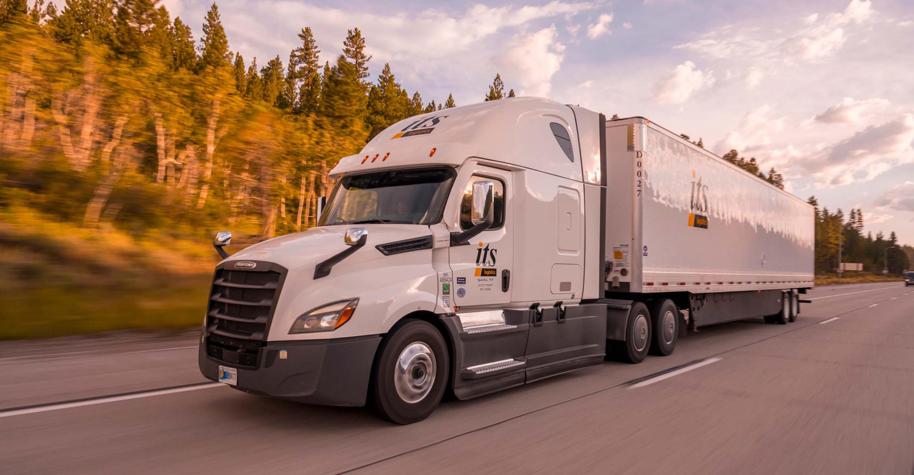 A tractor trailer driving on the interstate.