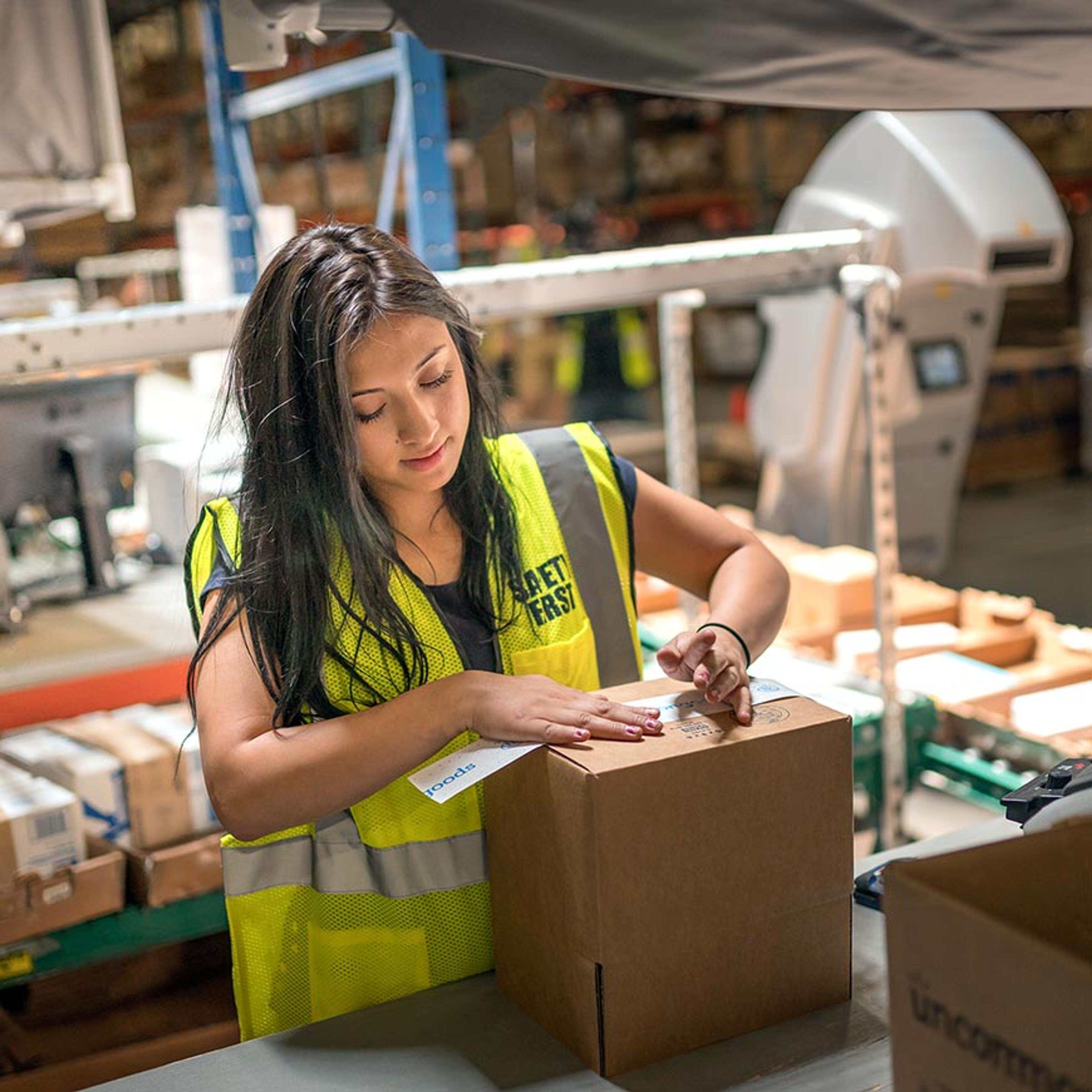 warehouse employee taping boxes