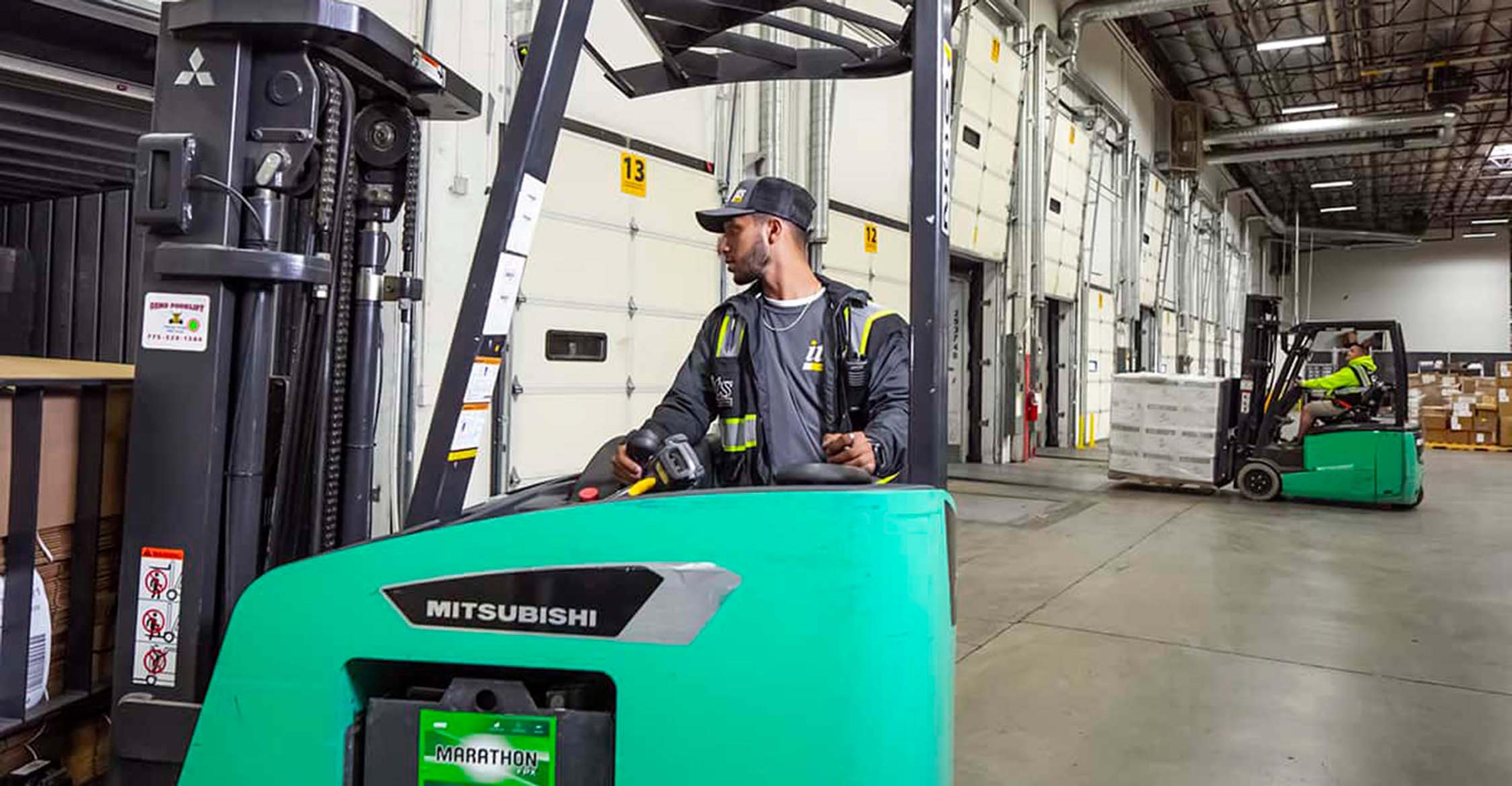 An ITS team member loading pallets onto a truck