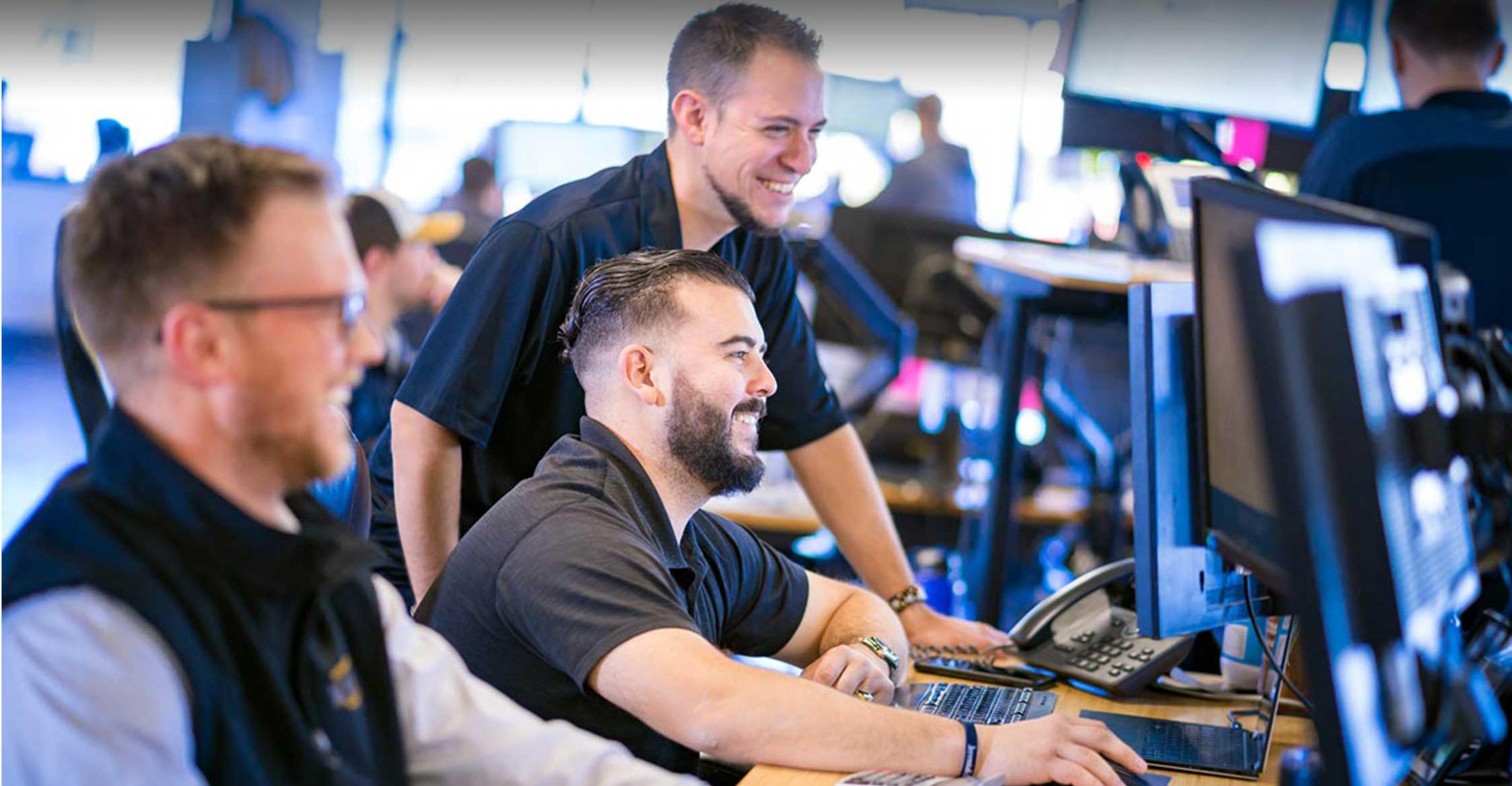 3 ITS employees looking at their computers.