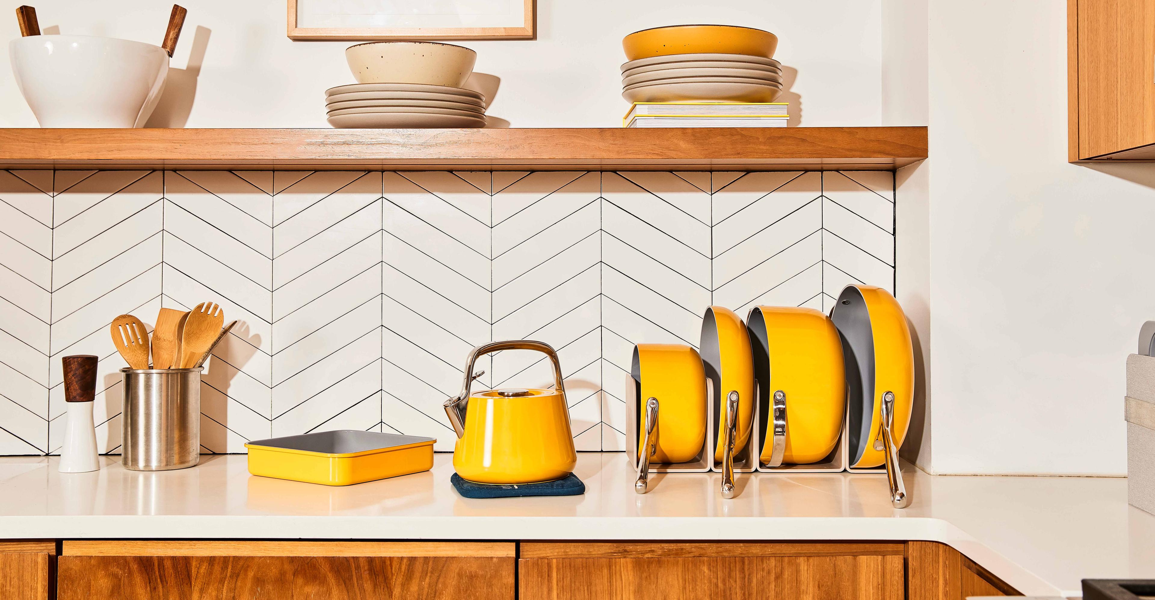 A set of yellow matching cookware in a kitchen