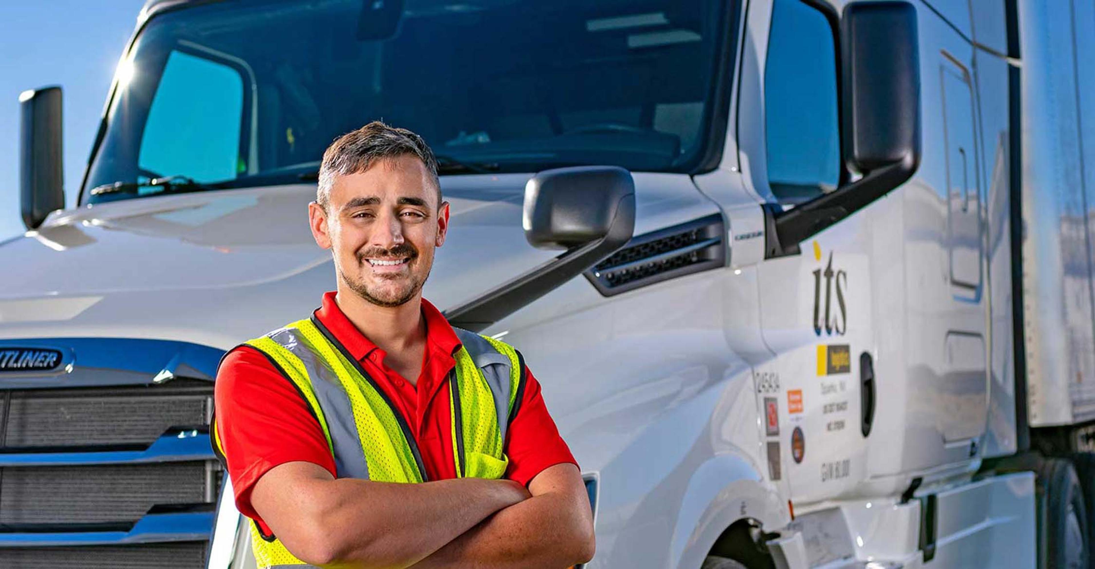 An ITS driver standing in front of a truck