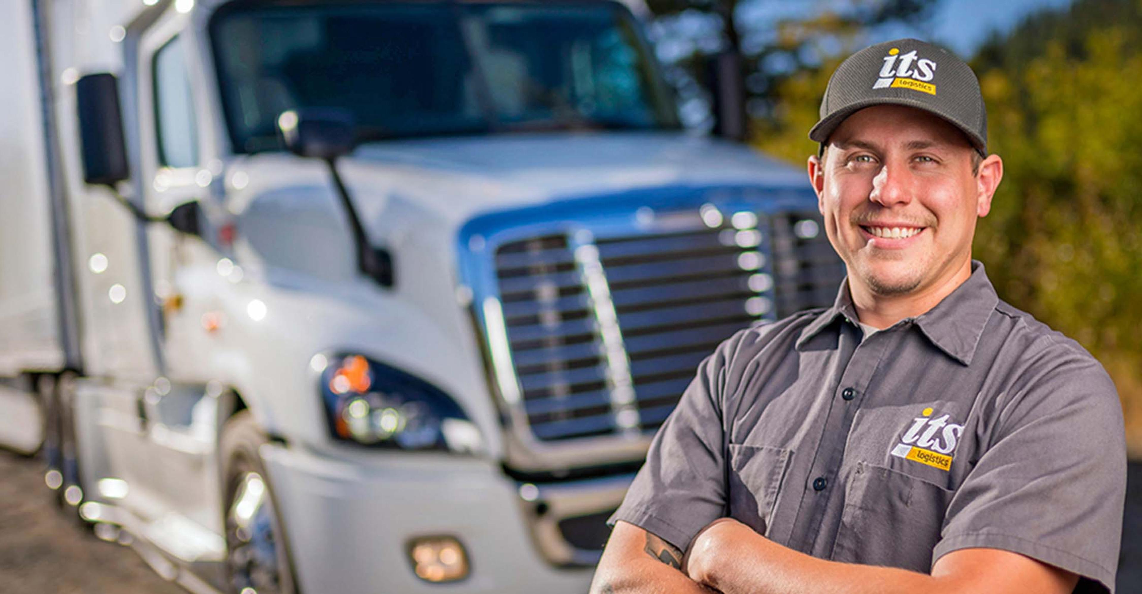 An ITS driver standing in front of a truck