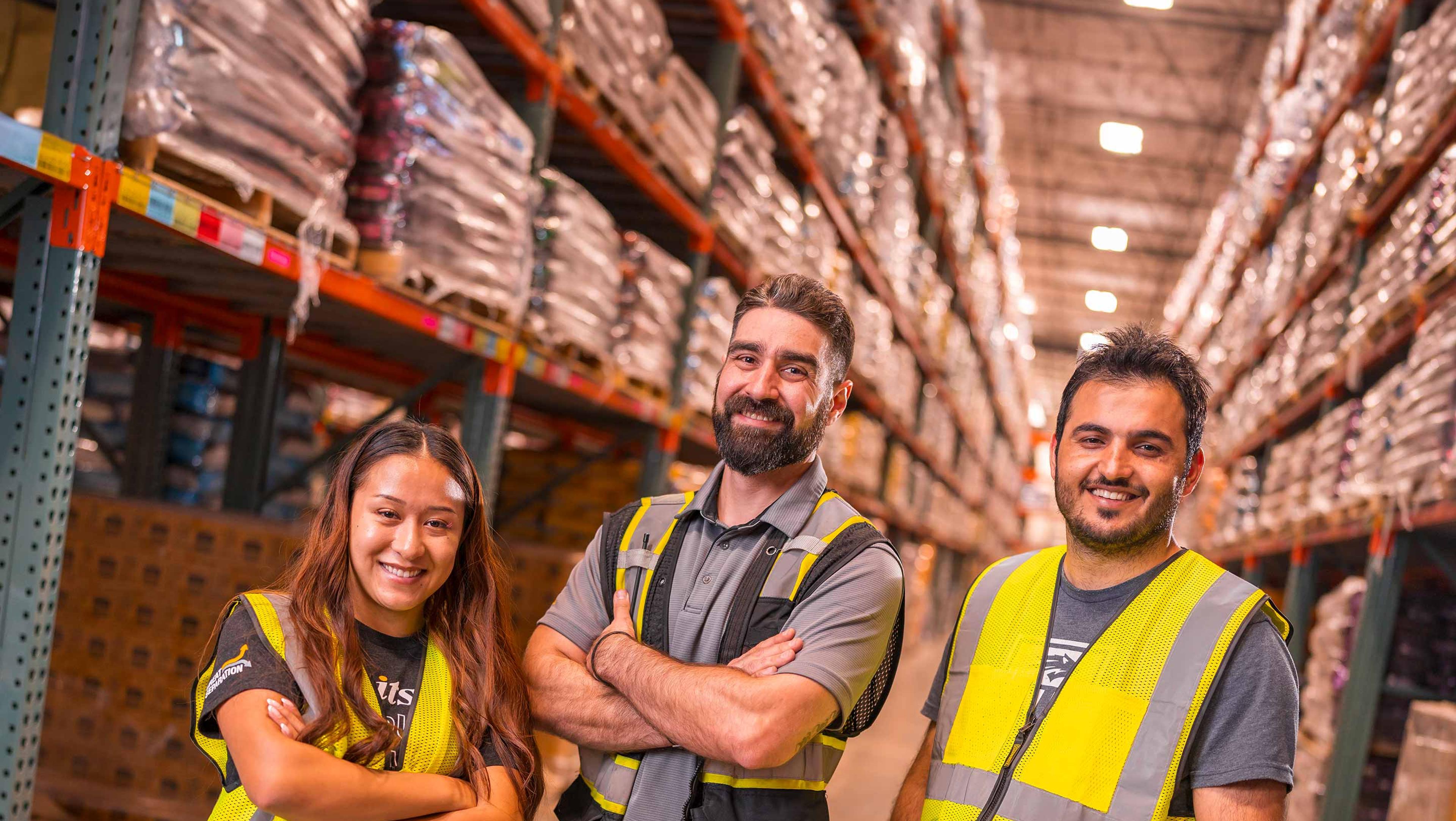 three smiling warehouse workers