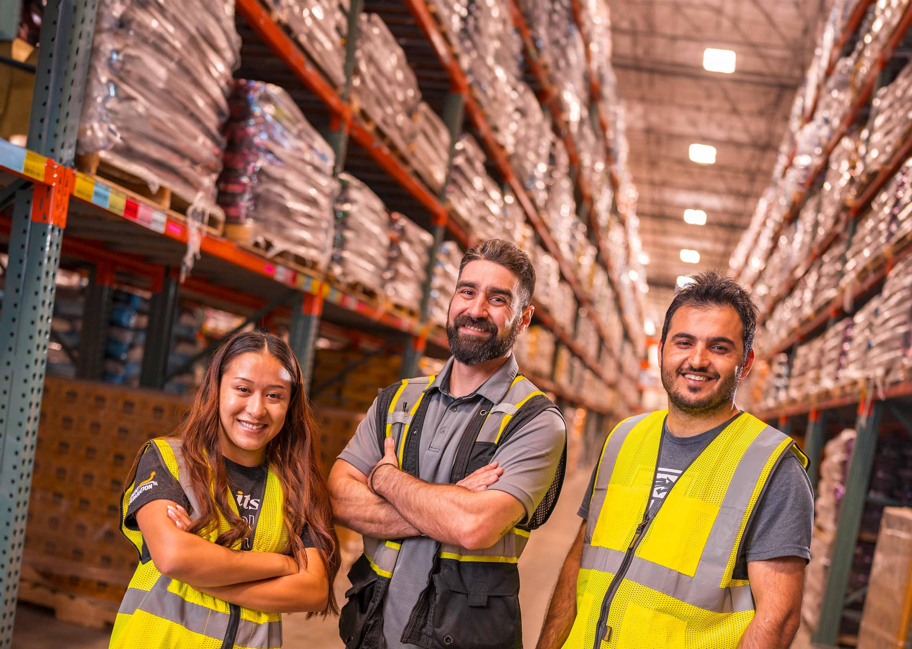 three smiling warehouse workers