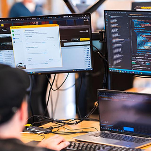 employee working on 3 different computer screens