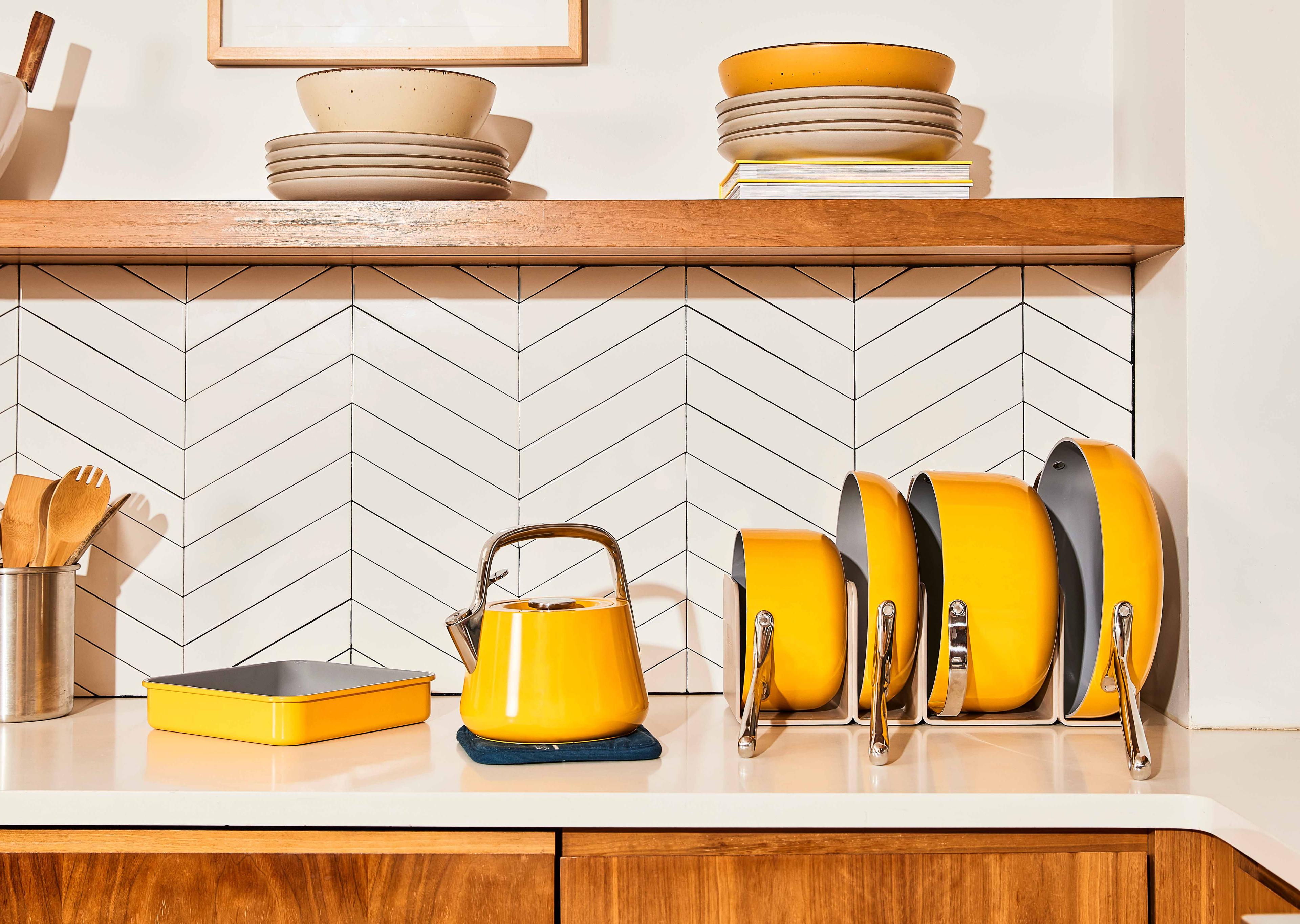 Set of matching yellow Caraway cookware on a kitchen countertop