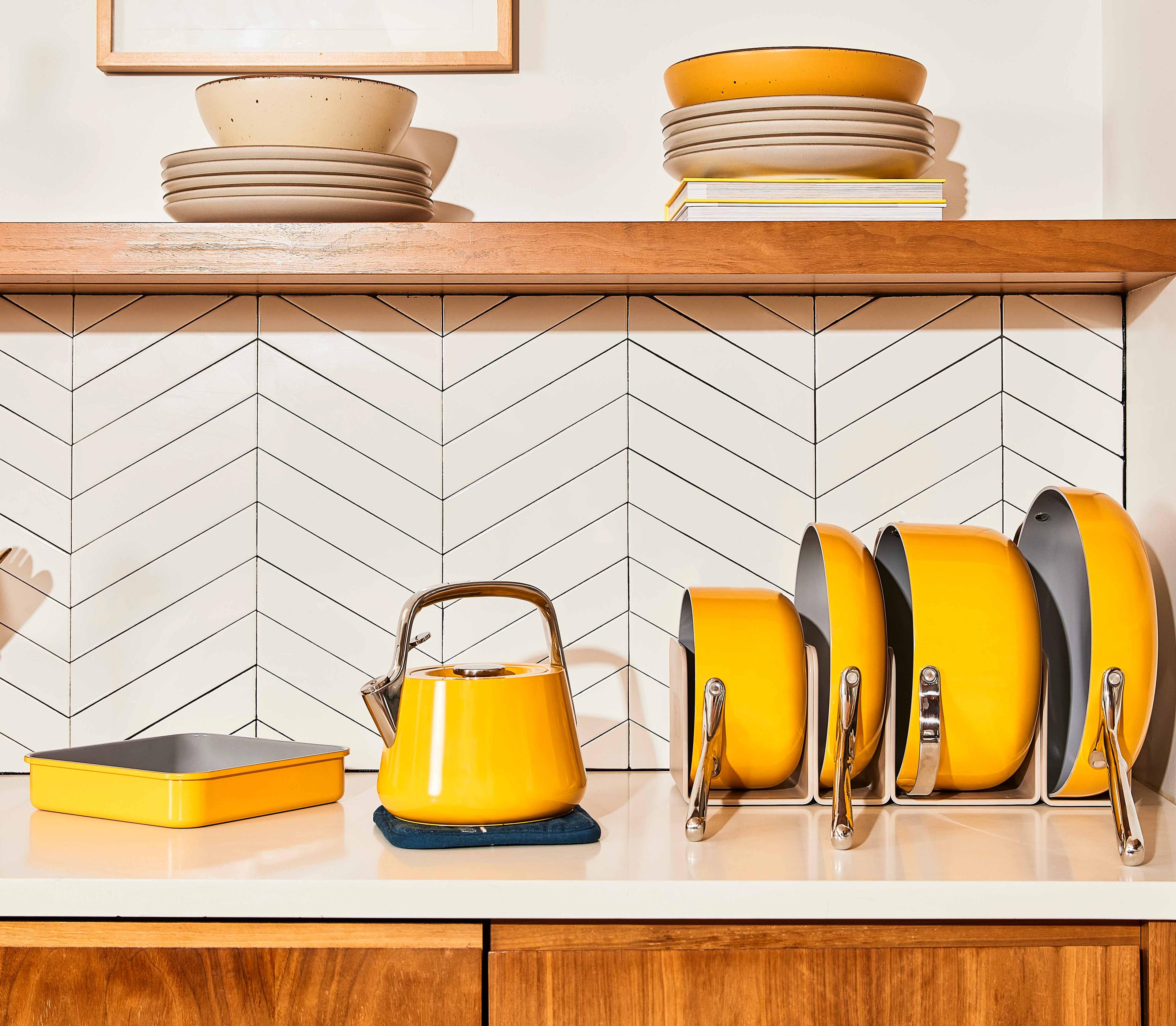 Set of matching yellow Caraway cookware on a kitchen countertop