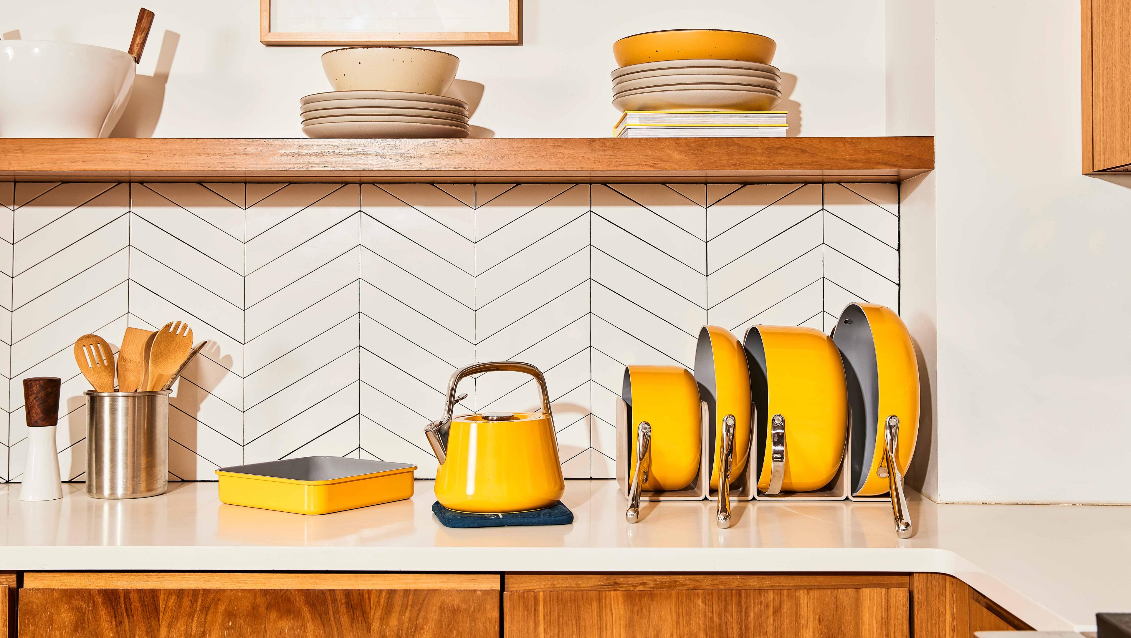 Set of matching yellow Caraway cookware on a kitchen countertop