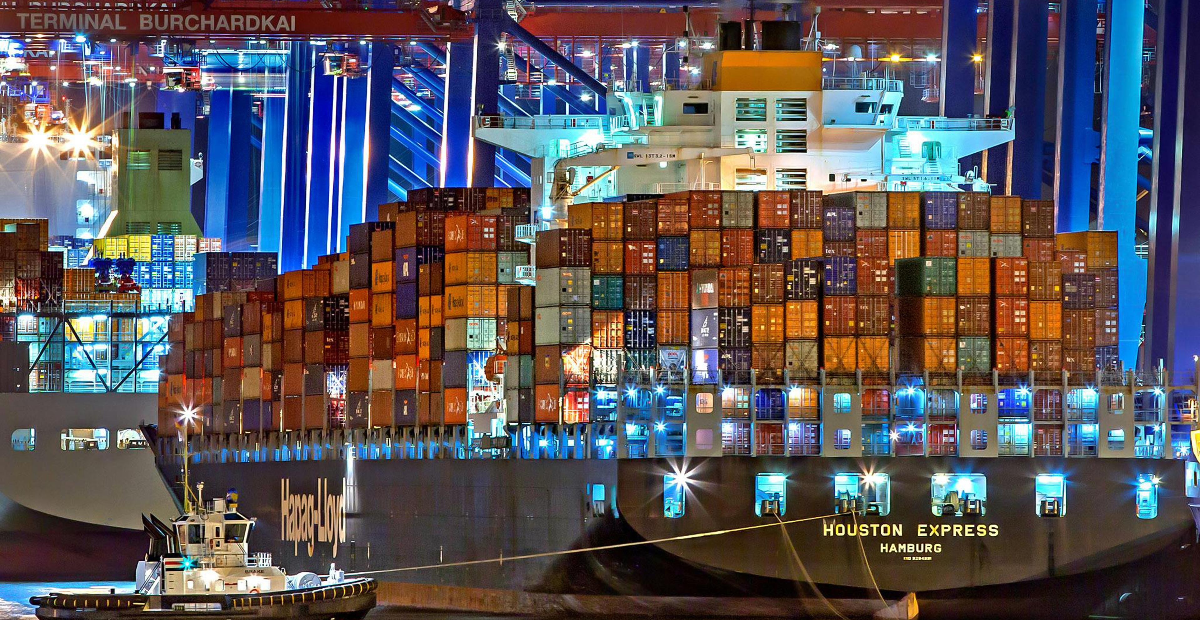 rear shot of loaded ship preparing to leave port at night
