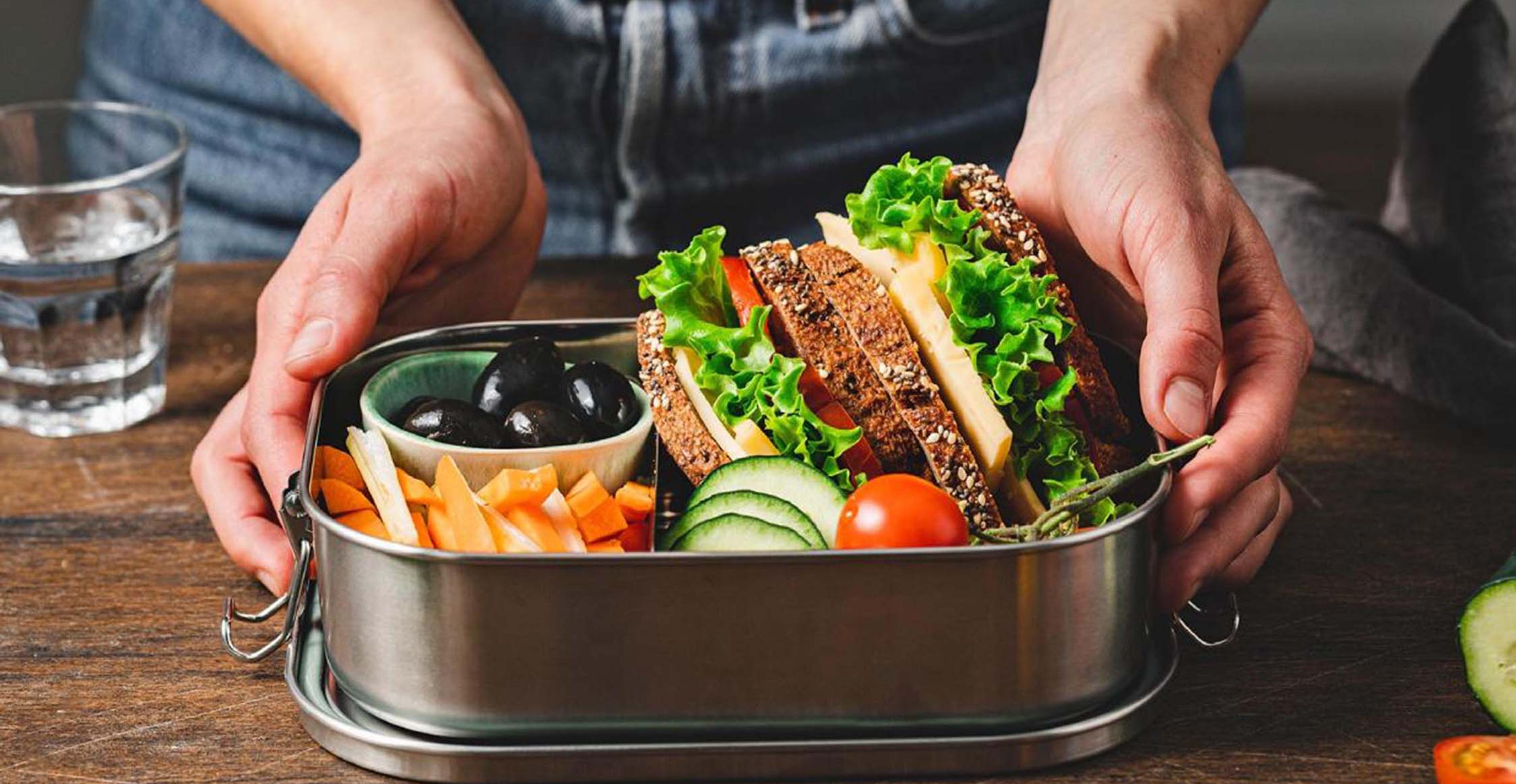A healthy pair of sandwiches in a metal lunch pail