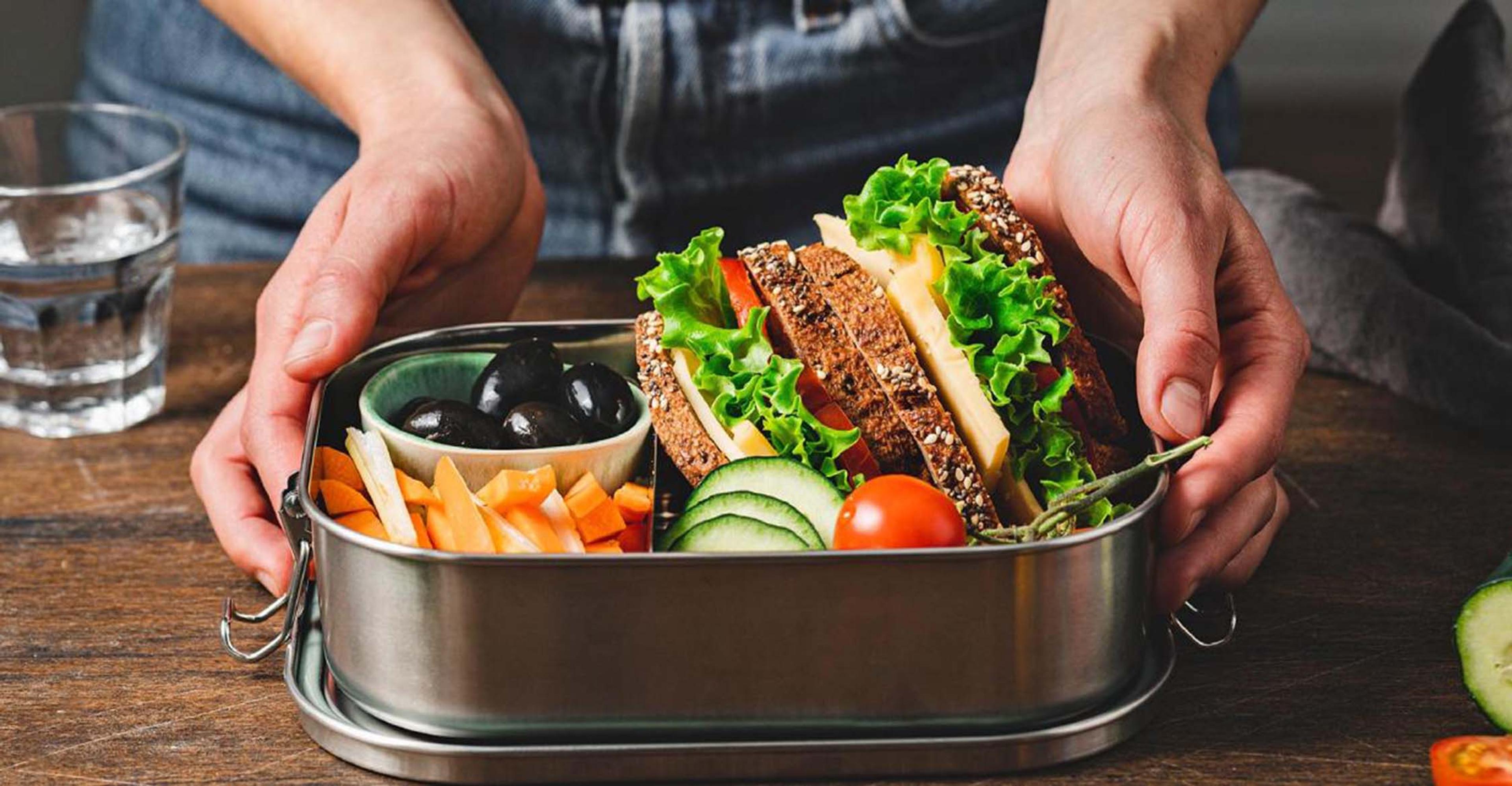 A healthy pair of sandwiches in a metal lunch pail